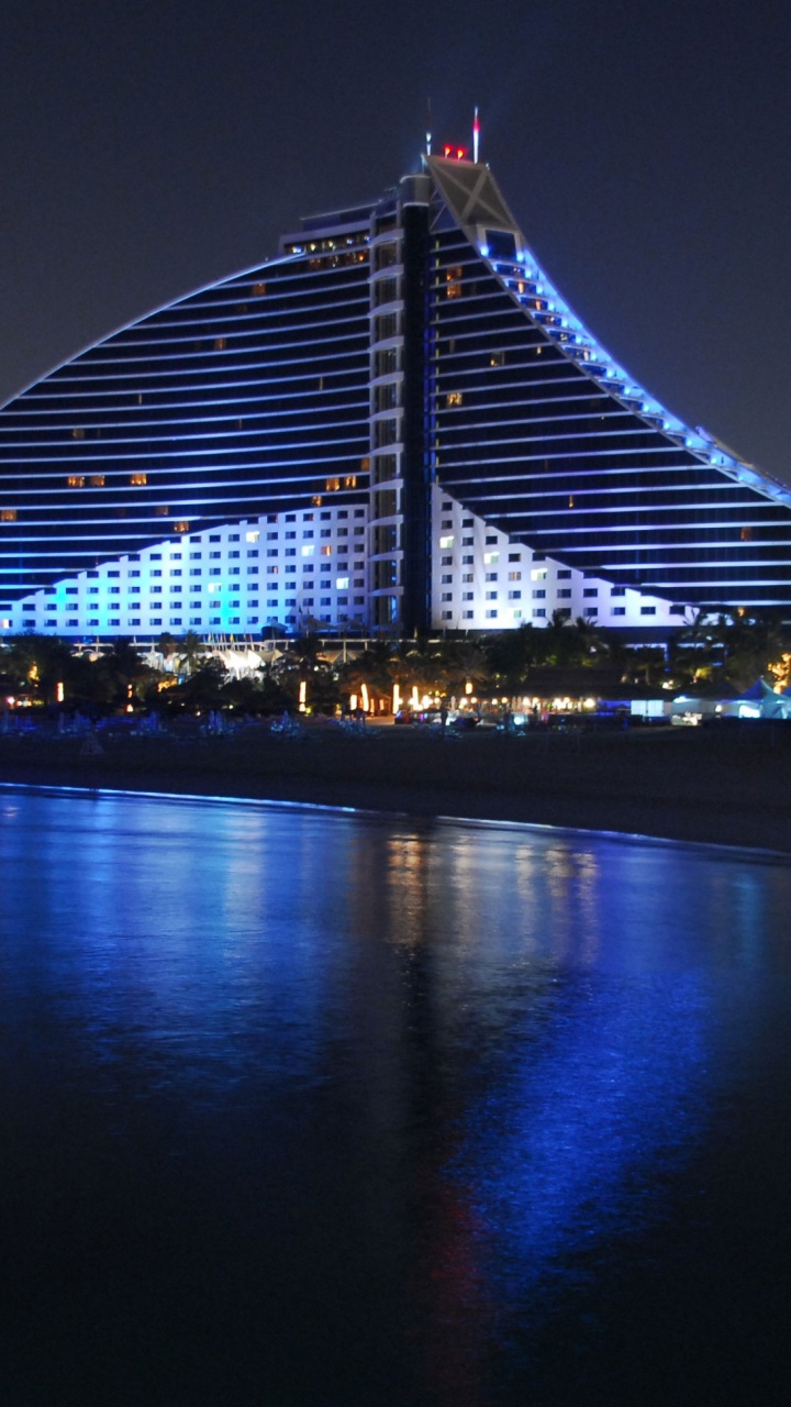 Puente Iluminado Sobre el Cuerpo de Agua Durante la Noche. Wallpaper in 720x1280 Resolution