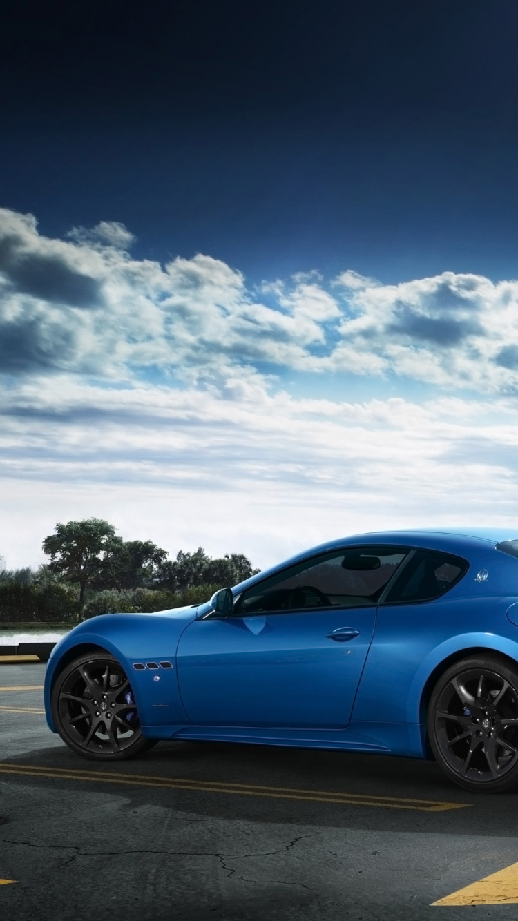 Blue Coupe on Gray Asphalt Road Under Blue and White Sunny Cloudy Sky During Daytime. Wallpaper in 750x1334 Resolution