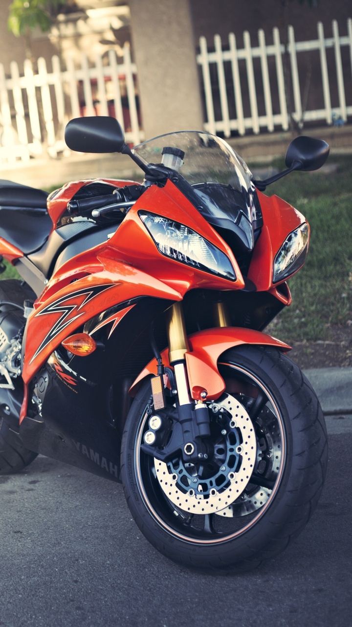 Orange-schwarzes Sportrad Tagsüber Unterwegs On. Wallpaper in 720x1280 Resolution