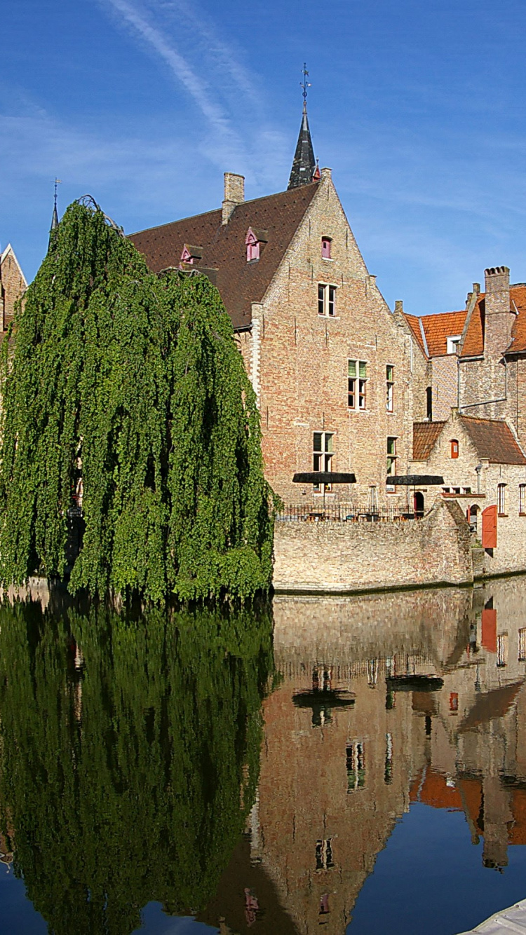 Edificio de Hormigón Marrón Junto al Cuerpo de Agua Durante el Día. Wallpaper in 750x1334 Resolution