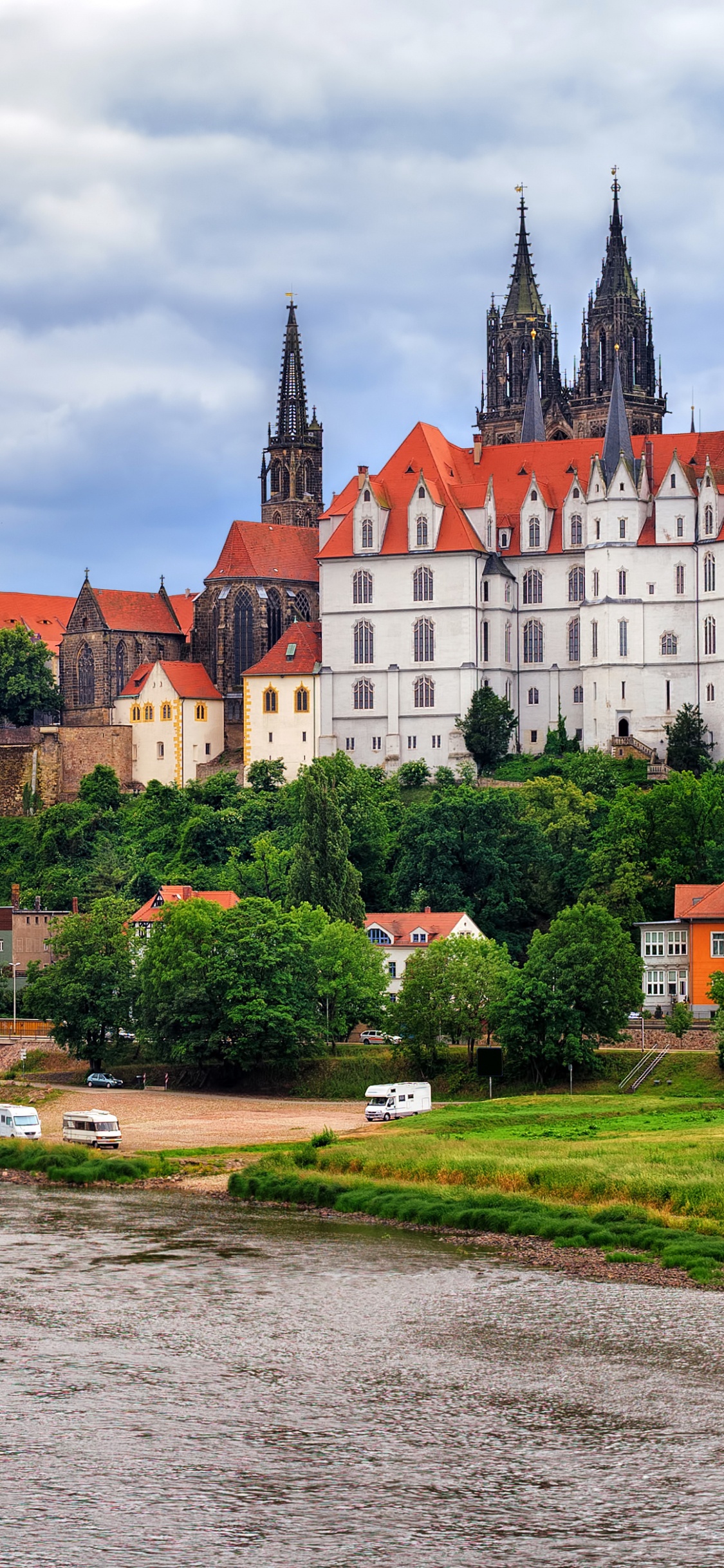 Braunes Und Graues Betongebäude in Der Nähe Eines Gewässers Tagsüber. Wallpaper in 1125x2436 Resolution