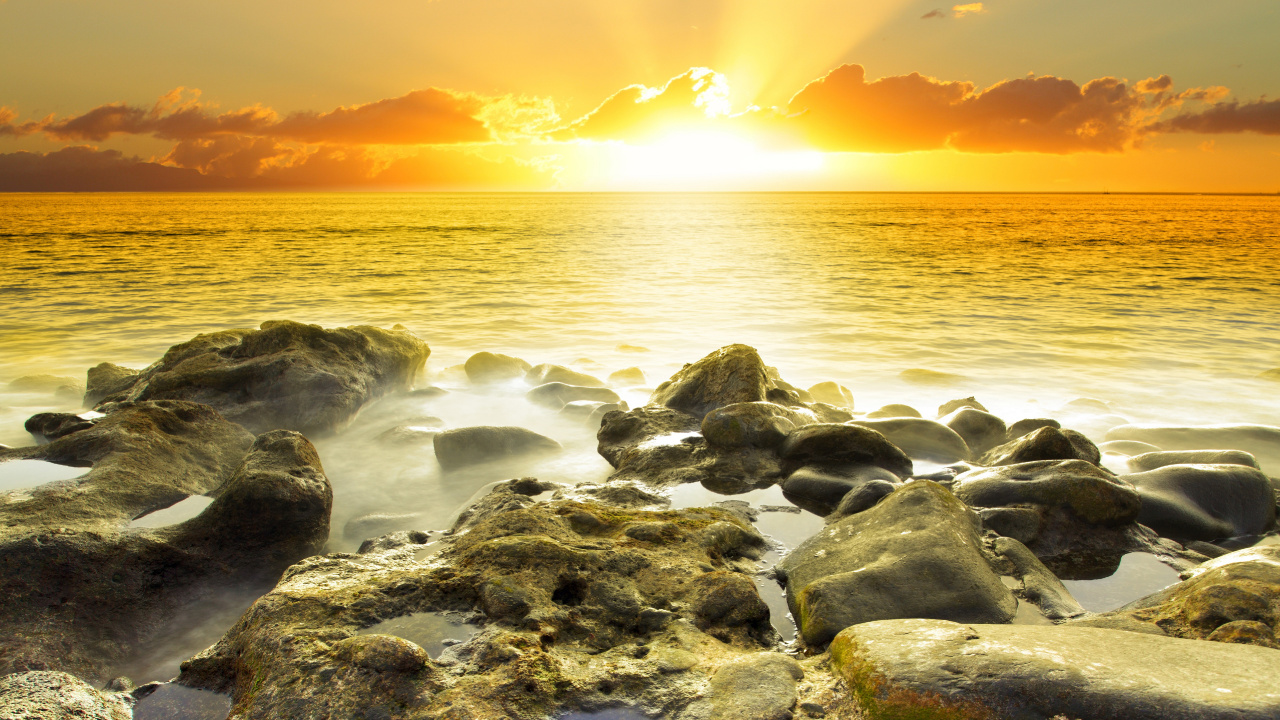 Graue Felsen Auf Gewässer Während Des Sonnenuntergangs. Wallpaper in 1280x720 Resolution