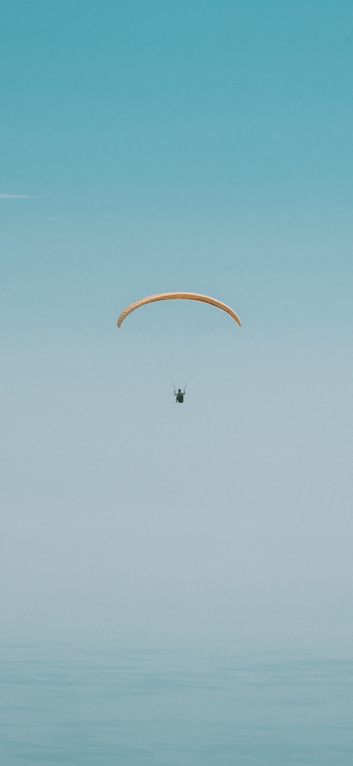 Person in Parachute Under Blue Sky During Daytime. Wallpaper in 1125x2436 Resolution