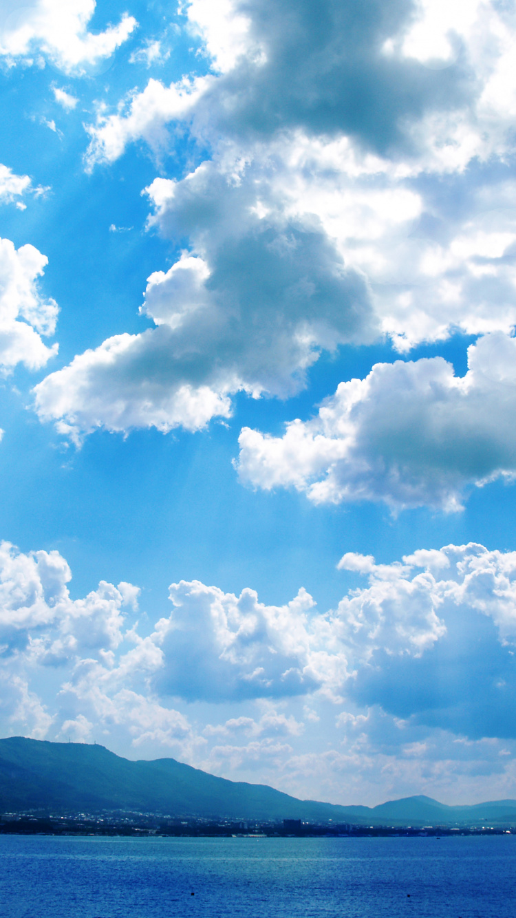 Mer Bleue Sous Ciel Bleu et Nuages Blancs Pendant la Journée. Wallpaper in 750x1334 Resolution