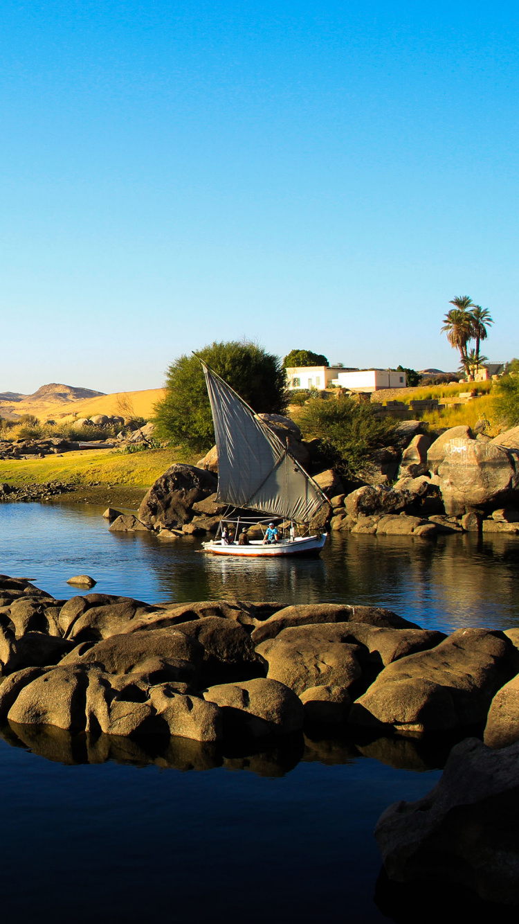 Rocas Marrones en el Cuerpo de Agua Durante el Día. Wallpaper in 750x1334 Resolution
