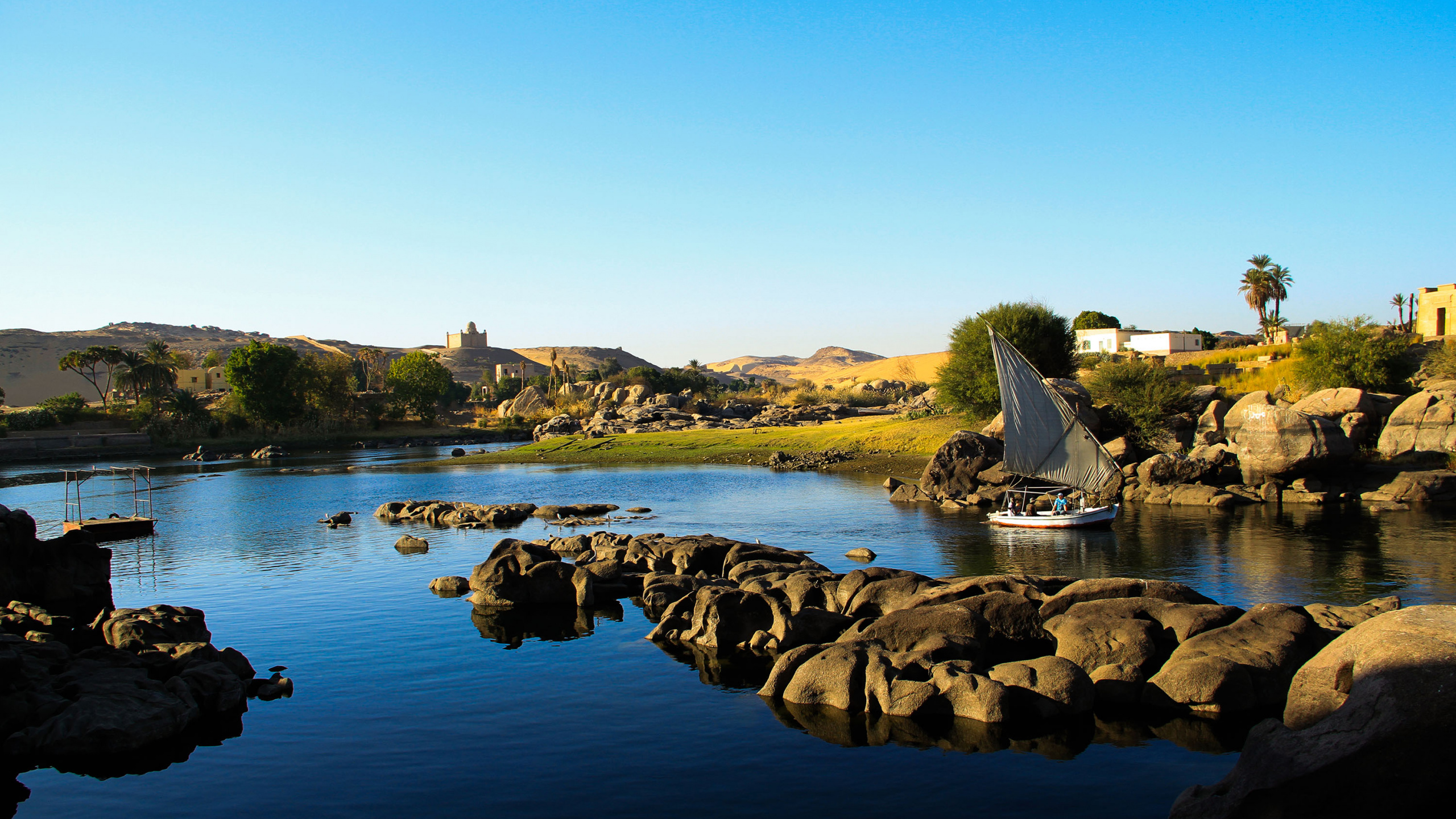 Brown Rocks on Body of Water During Daytime. Wallpaper in 2560x1440 Resolution