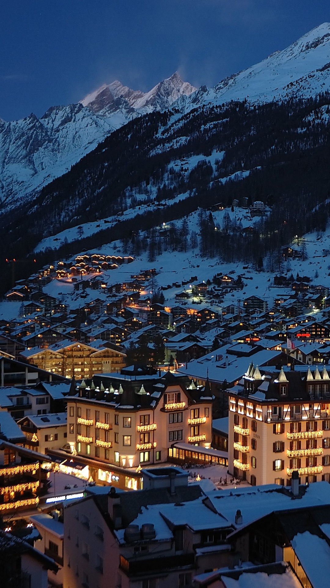 Braune Und Weiße Betongebäude in Der Nähe Von Schneebedeckten Bergen Tagsüber During. Wallpaper in 1080x1920 Resolution