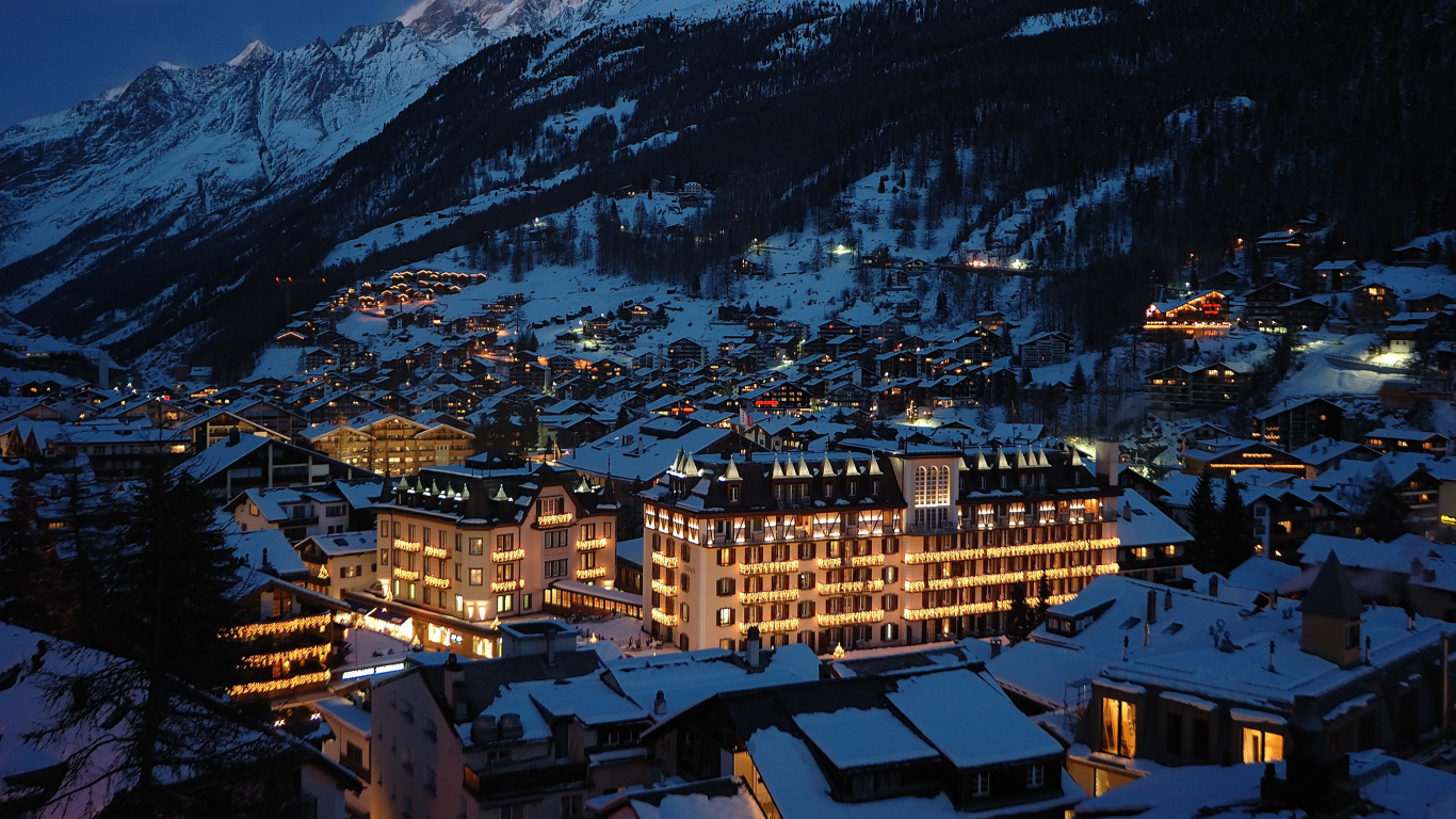 Brown and White Concrete Buildings Near Snow Covered Mountain During Daytime. Wallpaper in 1366x768 Resolution