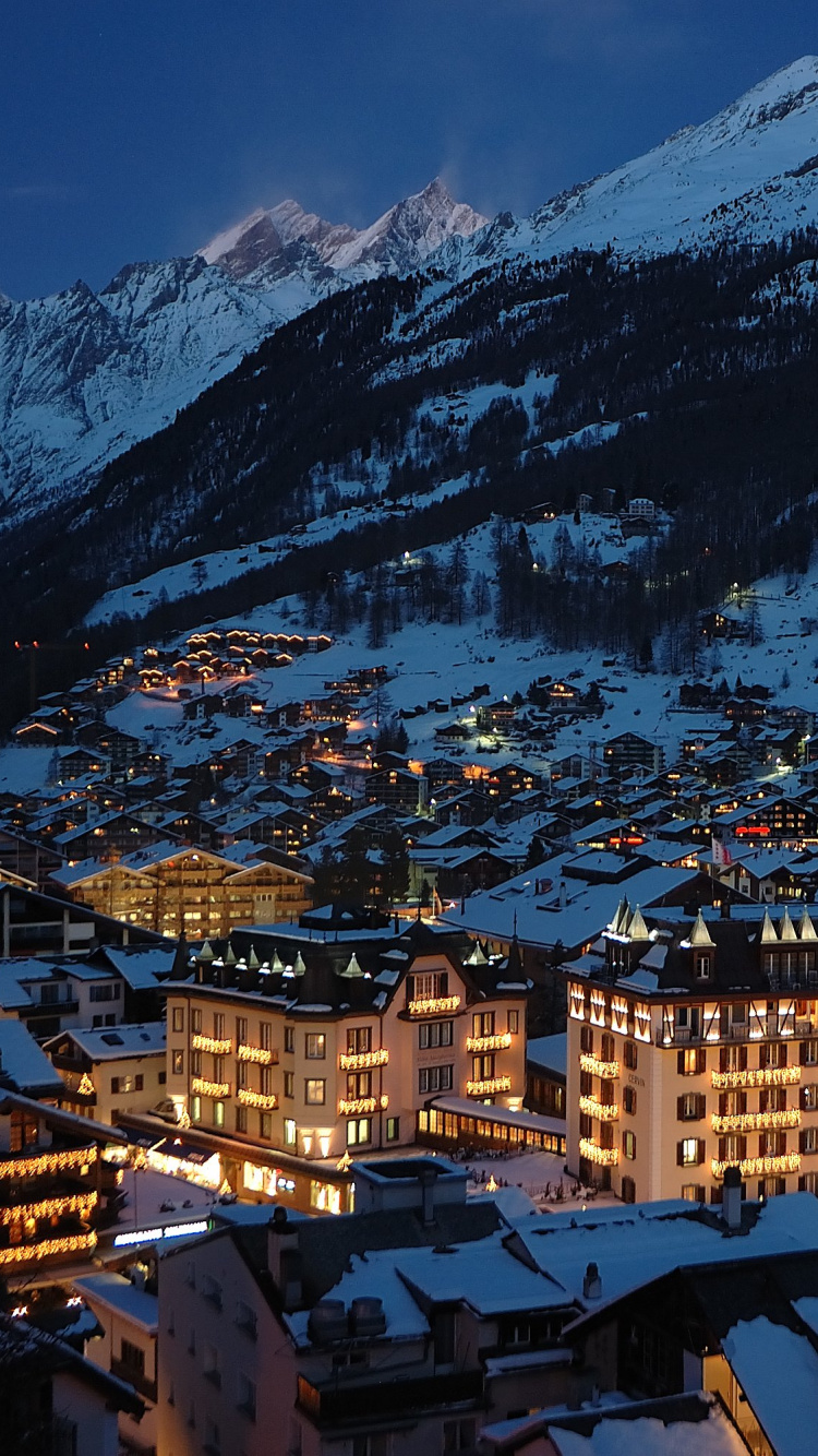 Brown and White Concrete Buildings Near Snow Covered Mountain During Daytime. Wallpaper in 750x1334 Resolution
