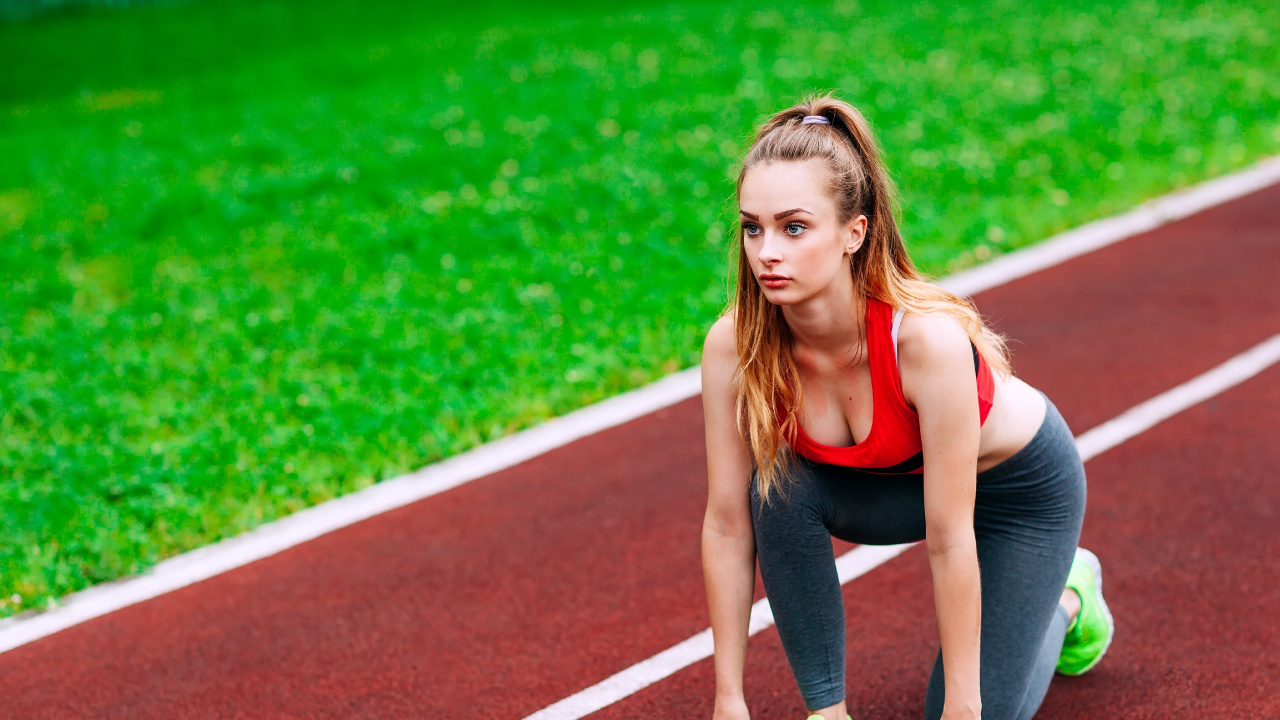 Woman in Black Tank Top and Green Shorts Running on Track Field During Daytime. Wallpaper in 1280x720 Resolution