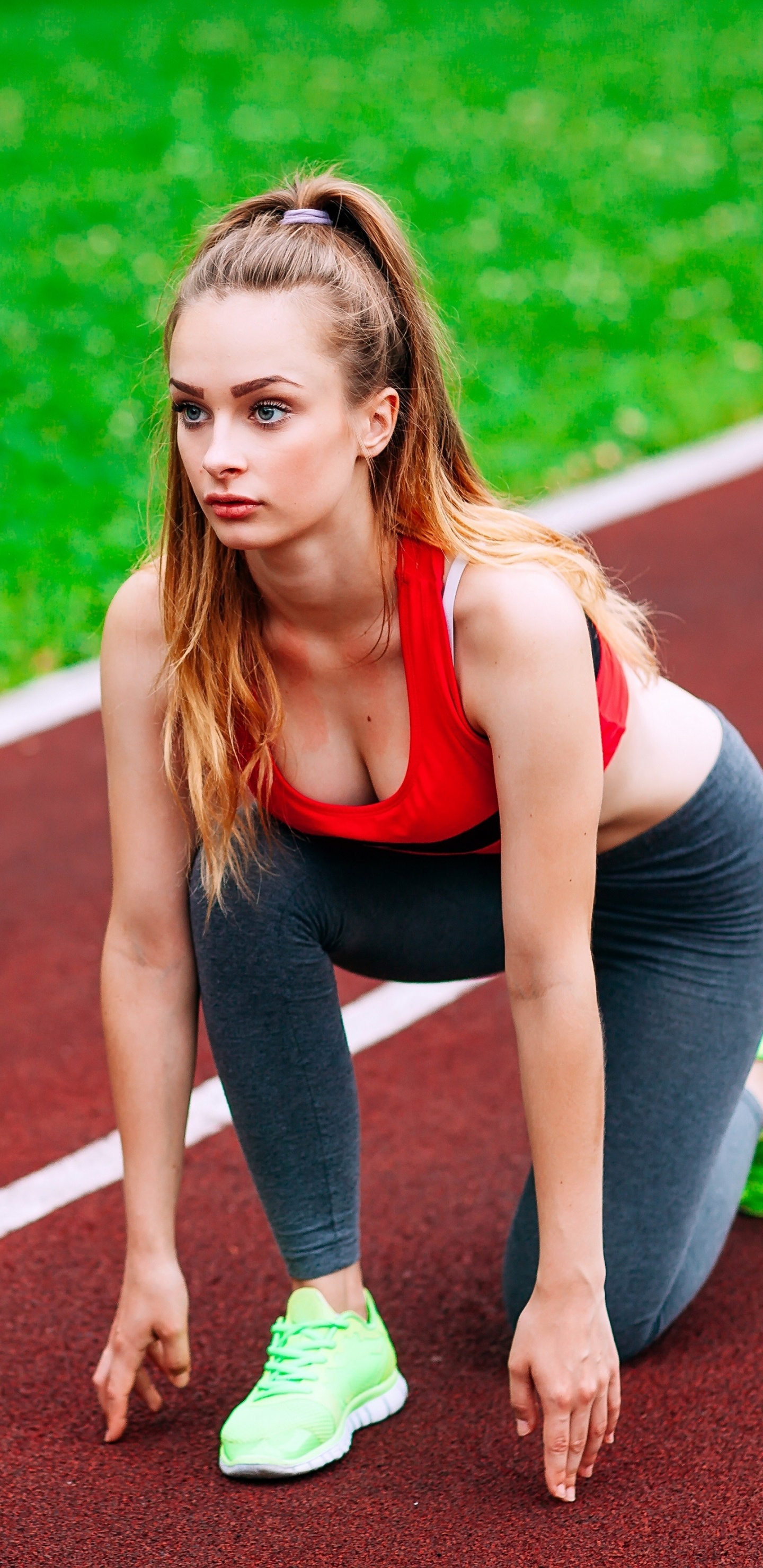 Woman in Black Tank Top and Green Shorts Running on Track Field During Daytime. Wallpaper in 1440x2960 Resolution