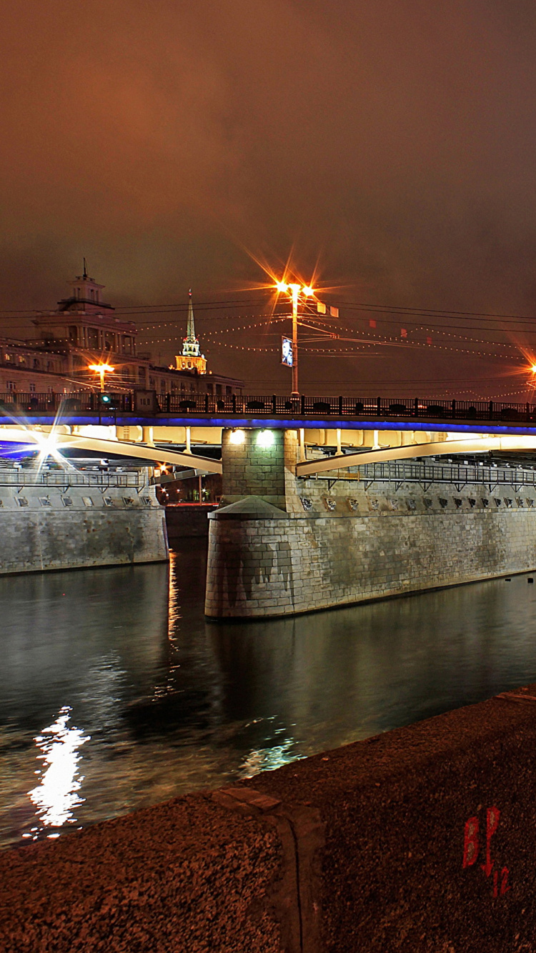 Brown Concrete Bridge Over River During Night Time. Wallpaper in 750x1334 Resolution