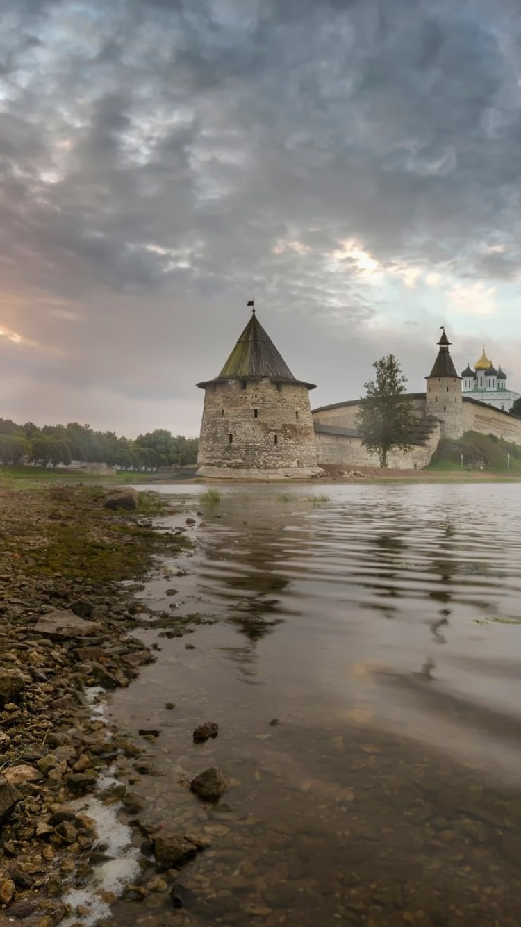 Bâtiment en Béton Gris Près D'un Plan D'eau Sous un Ciel Nuageux Pendant la Journée. Wallpaper in 750x1334 Resolution