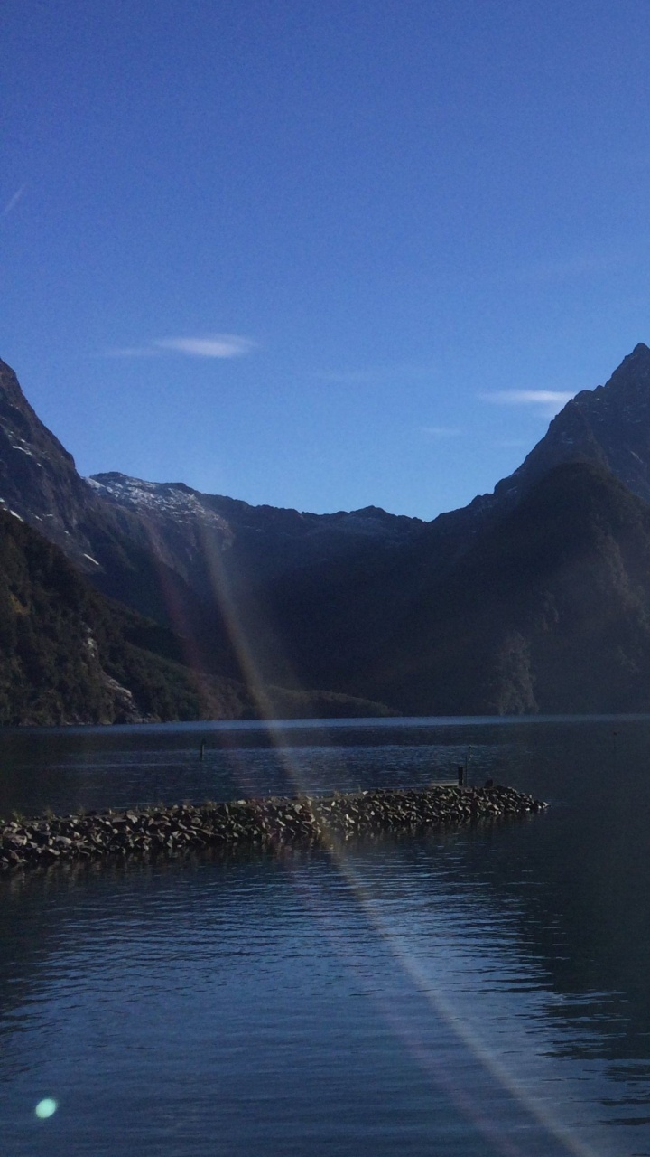 Body of Water Near Mountain Under Blue Sky During Daytime. Wallpaper in 720x1280 Resolution