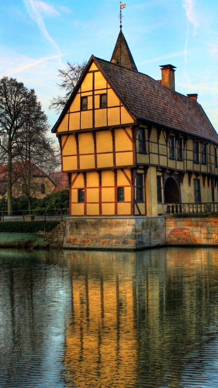 Bâtiment en Béton Marron et Blanc Près D'un Plan D'eau Pendant la Journée. Wallpaper in 720x1280 Resolution