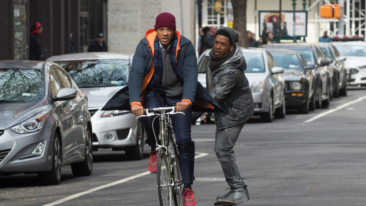 Man in Black Jacket and Red Knit Cap Riding Bicycle on Road During Daytime. Wallpaper in 1280x720 Resolution