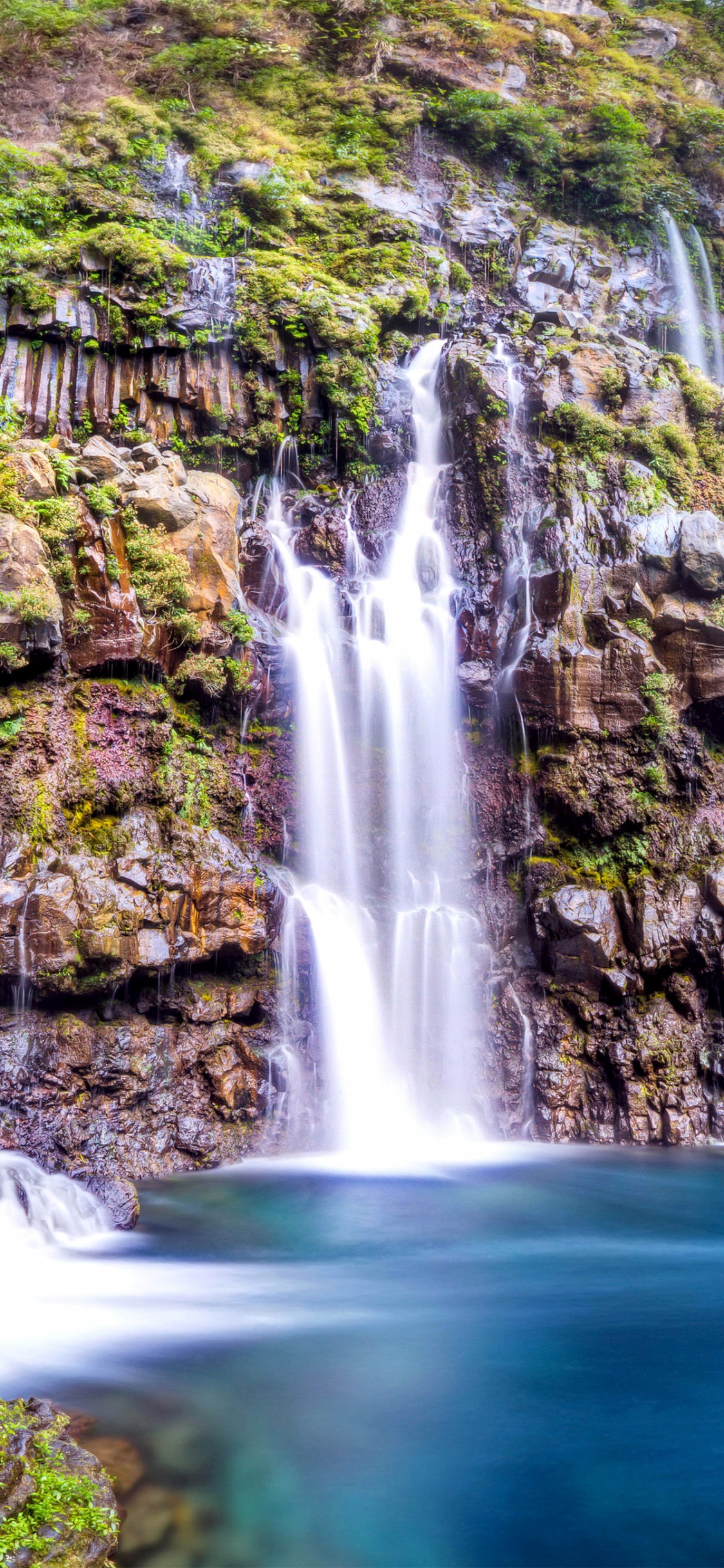 Waterfalls in The Middle of Green and Brown Mountain. Wallpaper in 1125x2436 Resolution