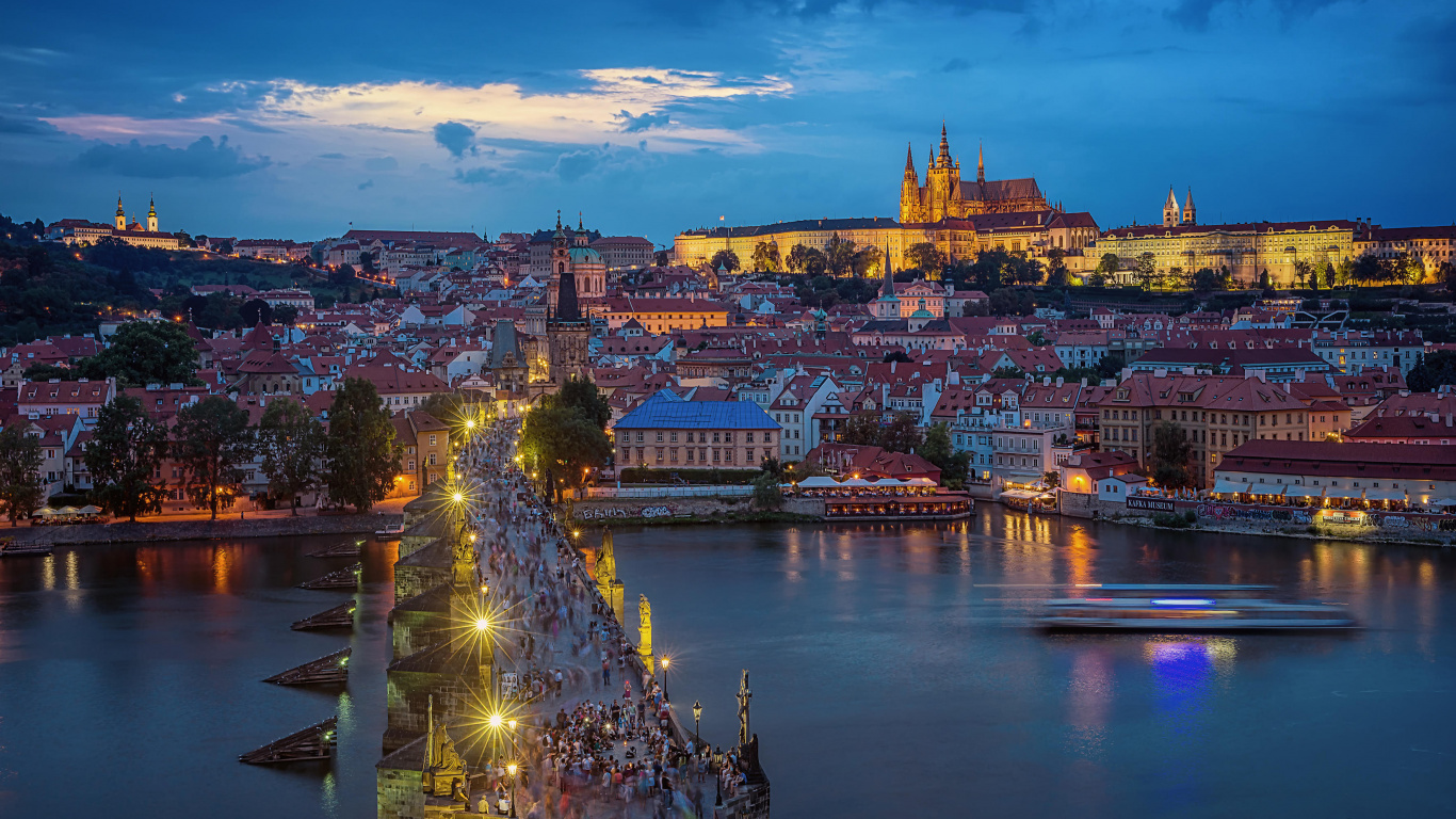 Bâtiments de la Ville Éclairés Près D'un Plan D'eau Pendant la Nuit. Wallpaper in 1366x768 Resolution