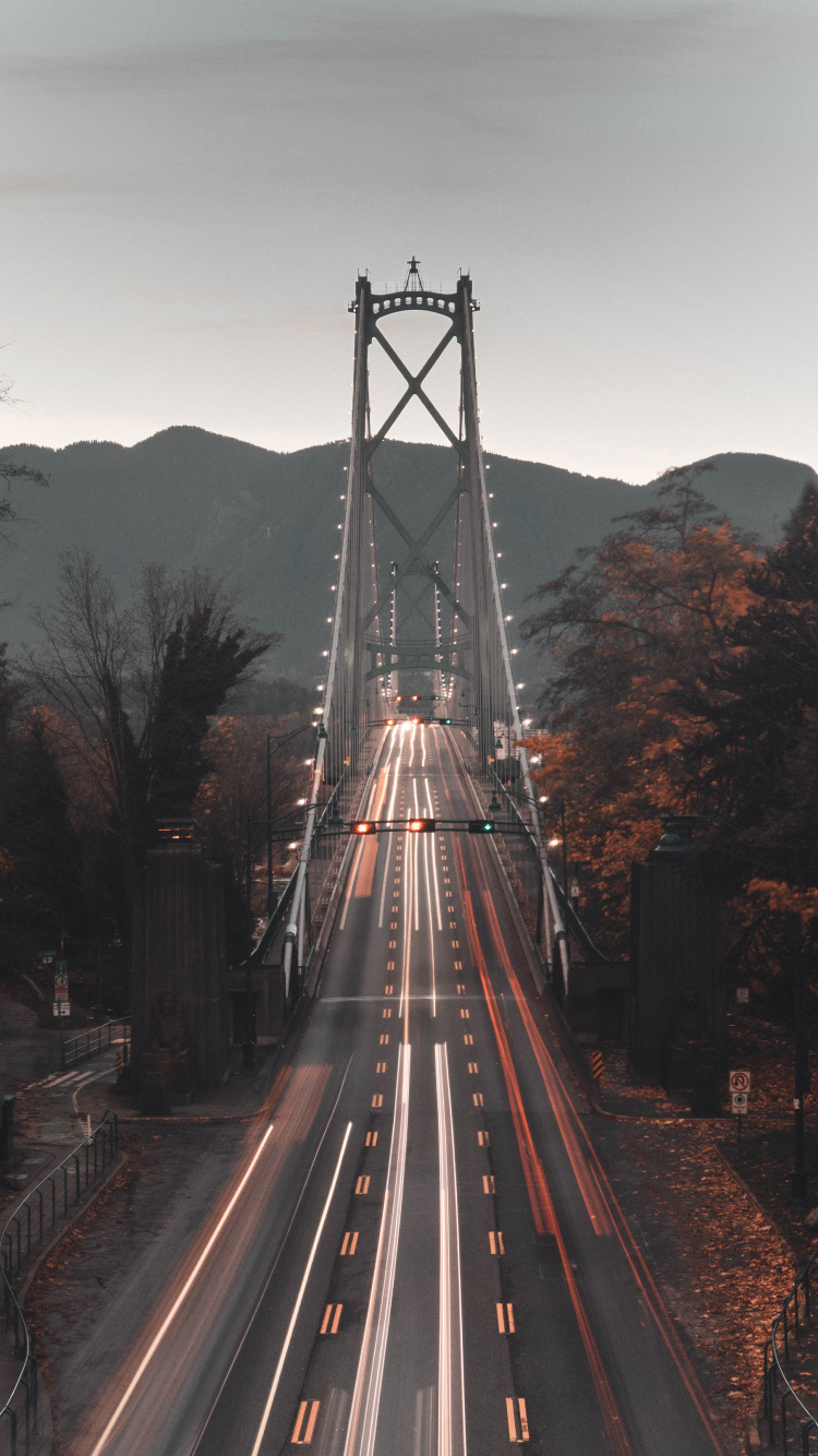 Zeitrafferaufnahmen Von Autos Auf Der Brücke Bei Nacht. Wallpaper in 750x1334 Resolution