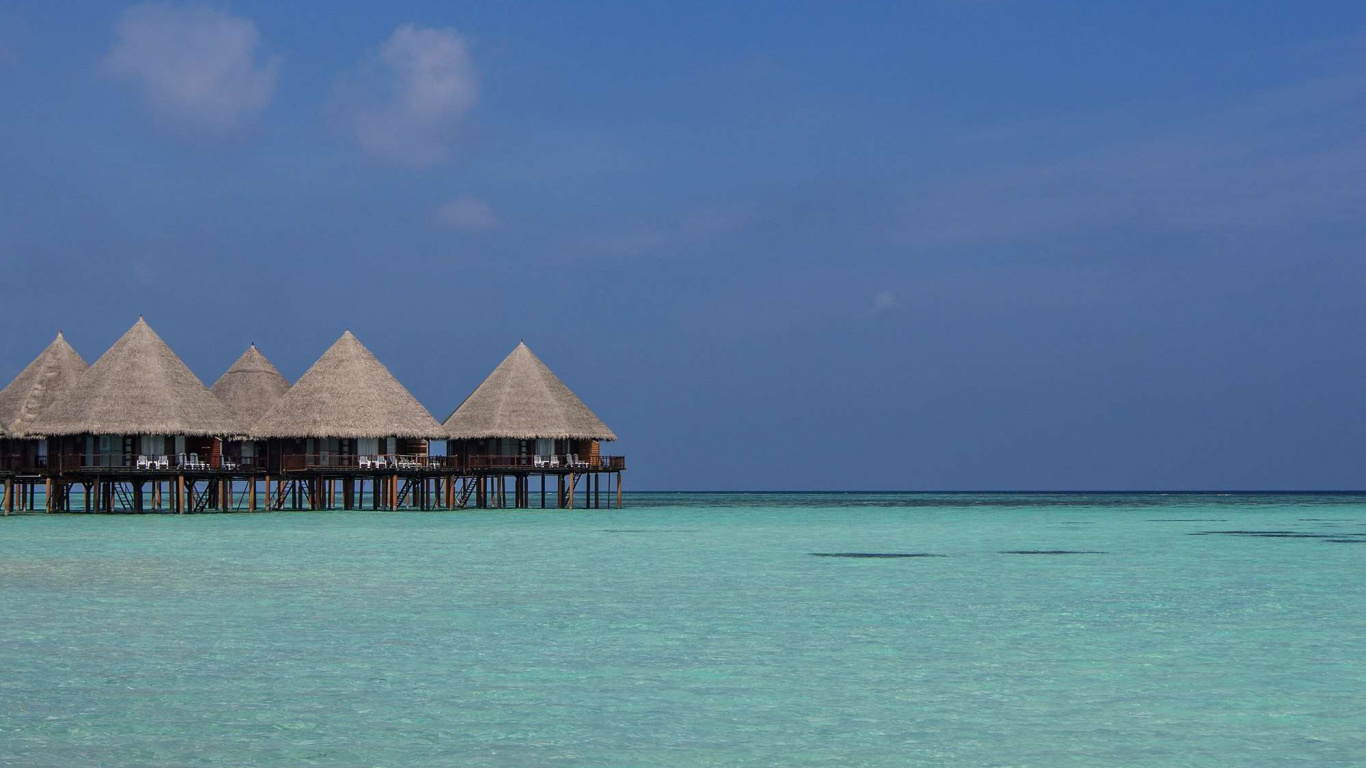 Braunes Holzhaus am Meer Unter Blauem Himmel Tagsüber. Wallpaper in 1366x768 Resolution