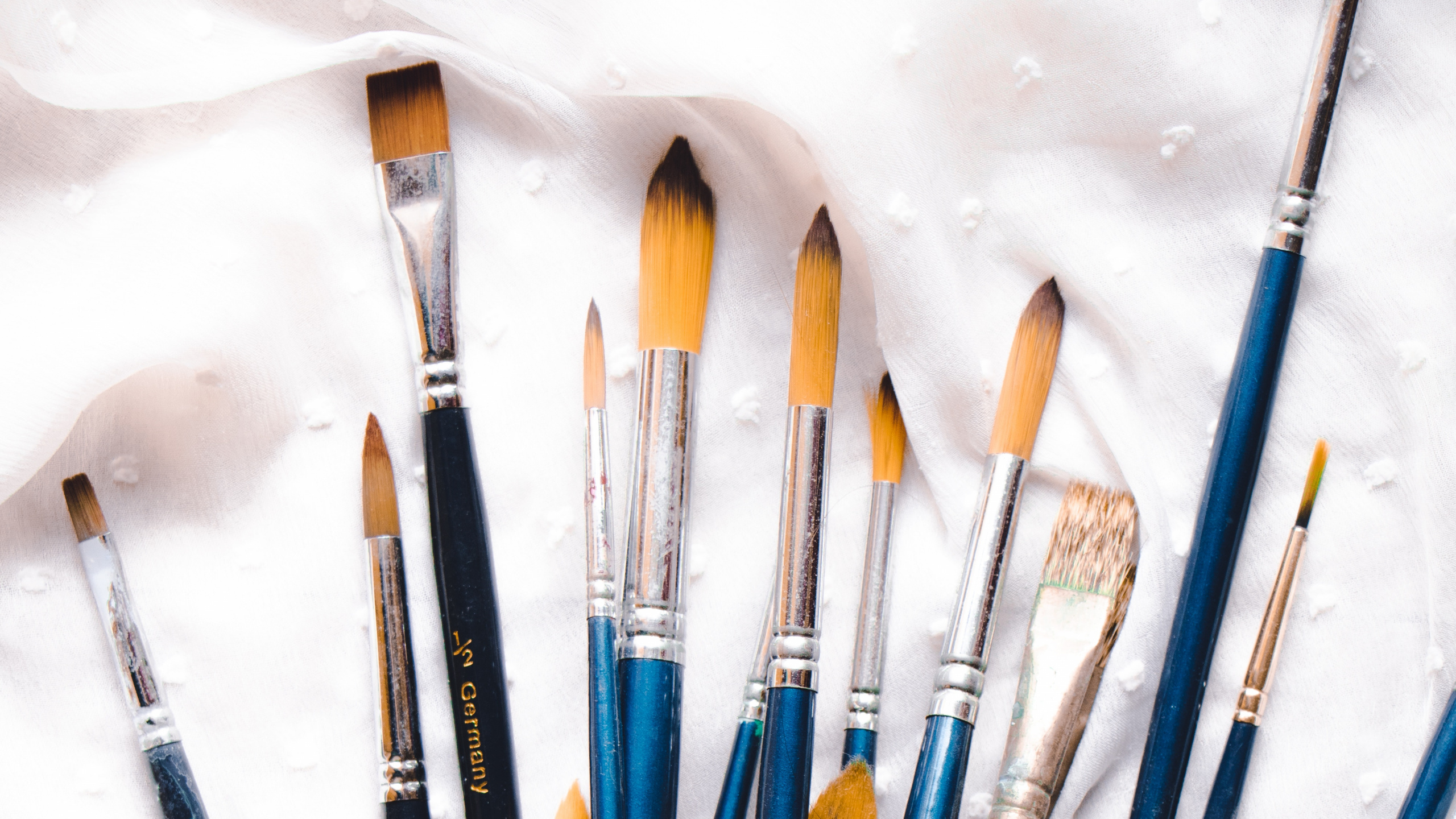 Assorted Color Paint Brushes on White Textile. Wallpaper in 2560x1440 Resolution