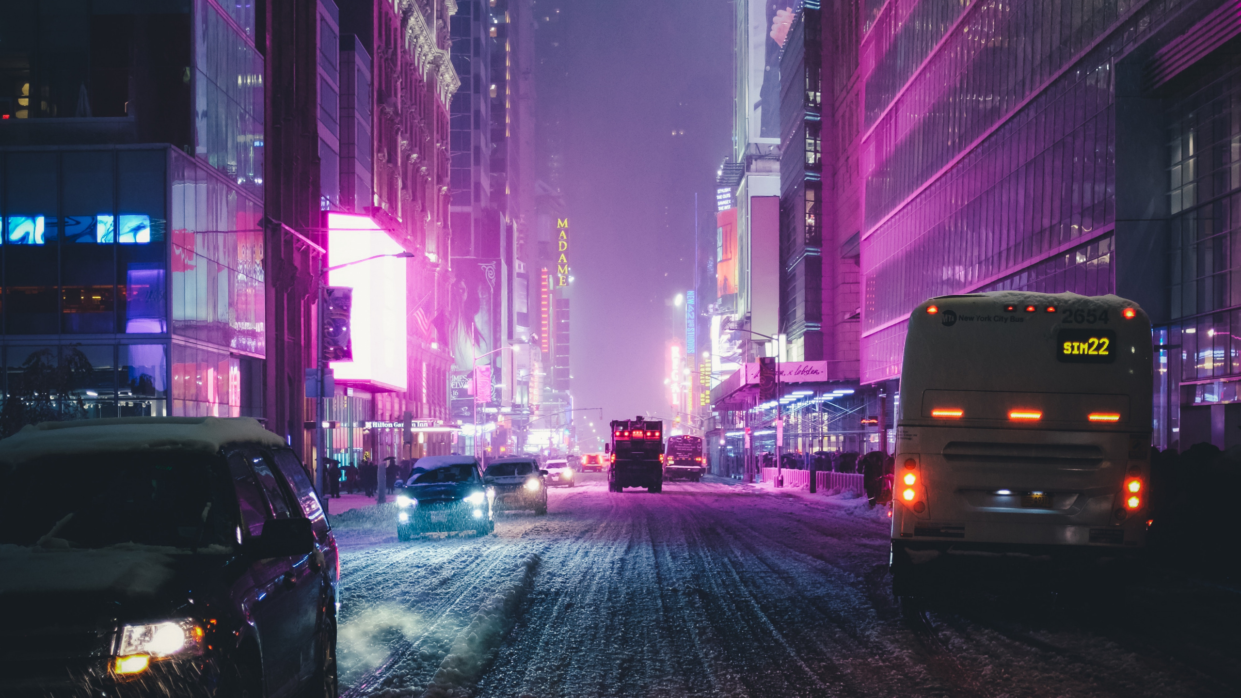 Coches en la Carretera Entre Edificios de Gran Altura Durante la Noche. Wallpaper in 2560x1440 Resolution