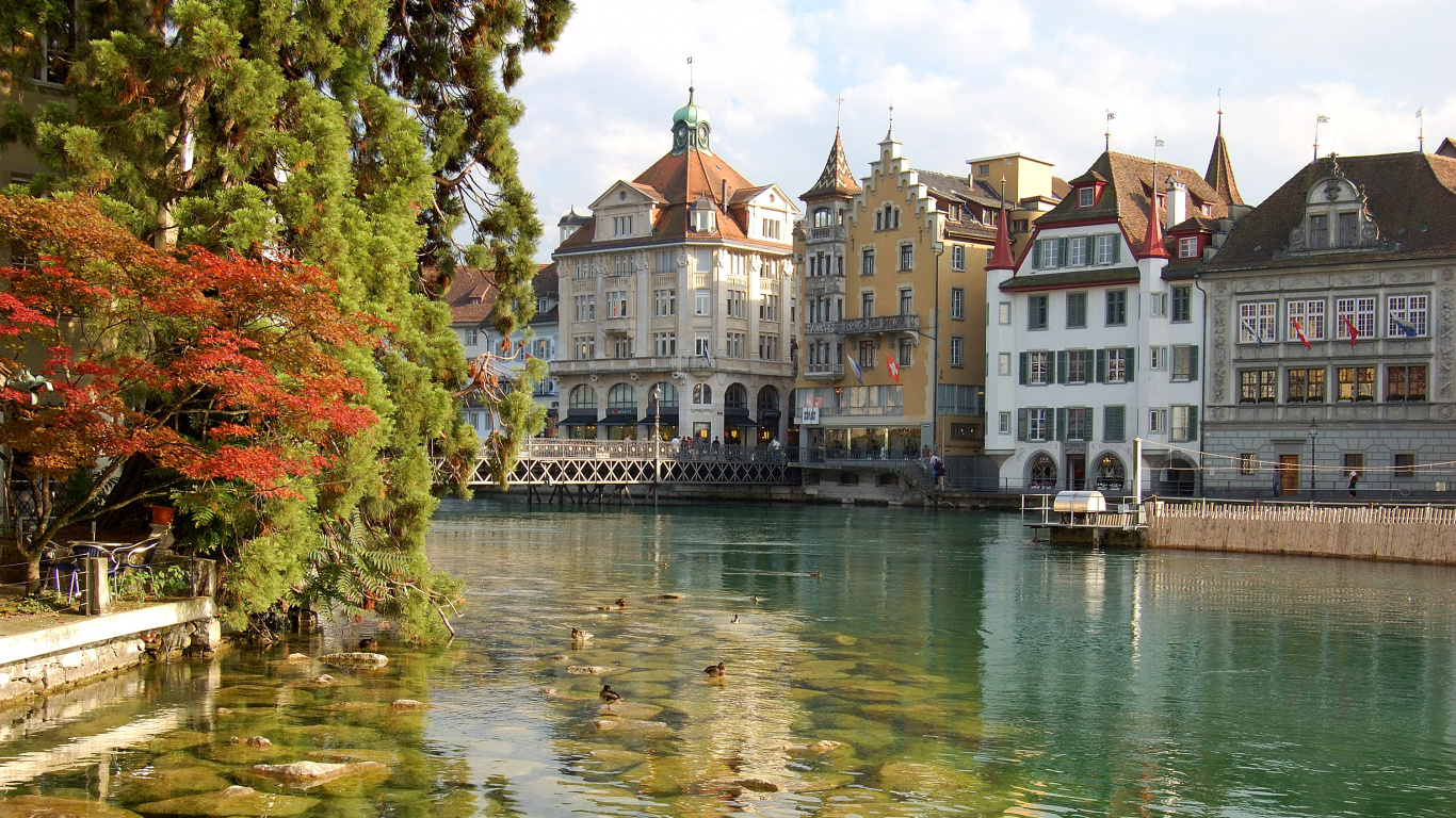 Body of Water Near Green Trees and White Concrete Building During Daytime. Wallpaper in 1366x768 Resolution
