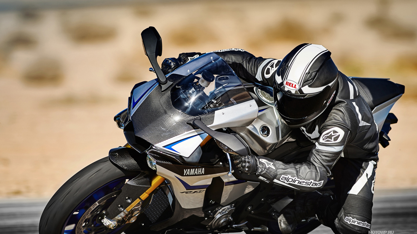 Man in Black and White Motorcycle Suit Riding on Orange and Black Sports Bike. Wallpaper in 1366x768 Resolution