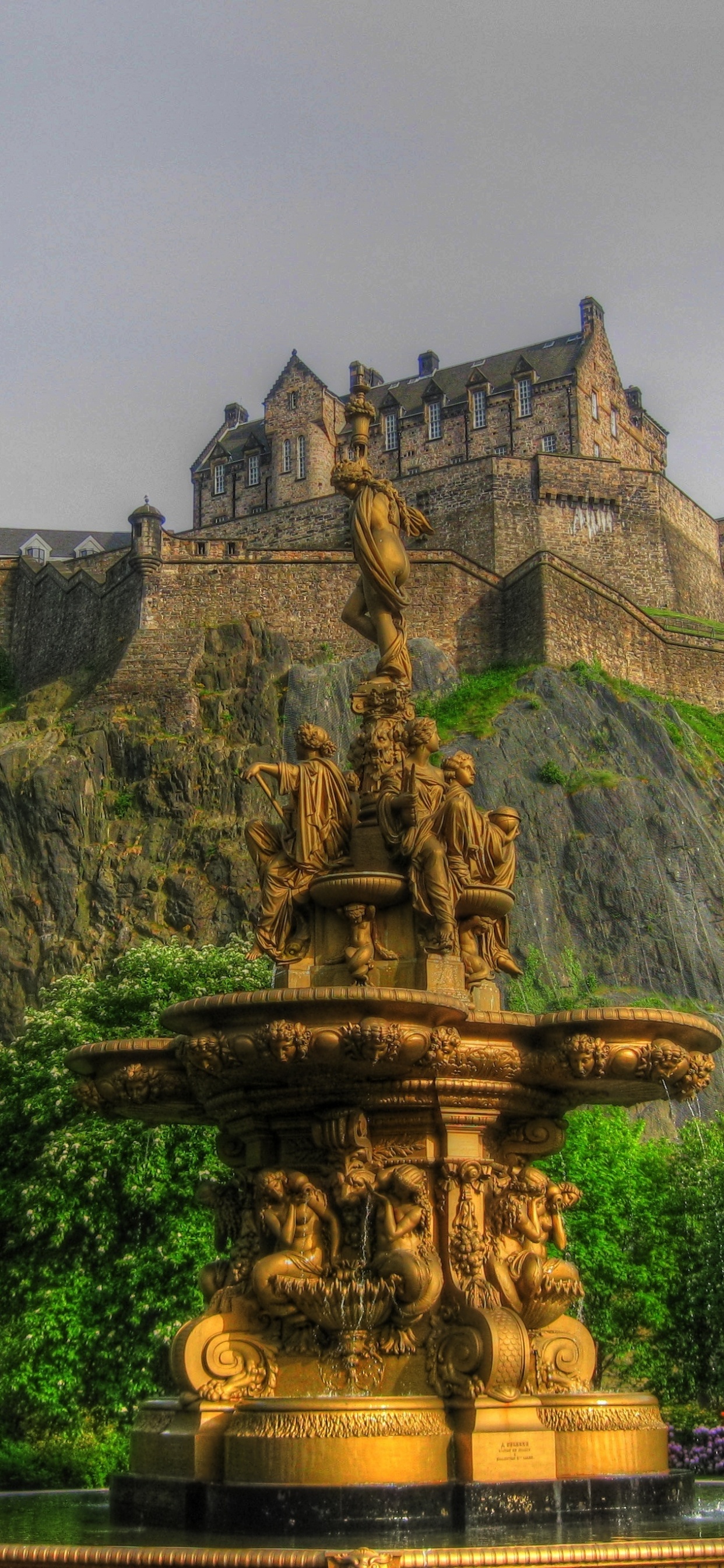 Brauner Betonbrunnen in Der Nähe Grüner Bäume Unter Weißen Wolken Tagsüber. Wallpaper in 1242x2688 Resolution