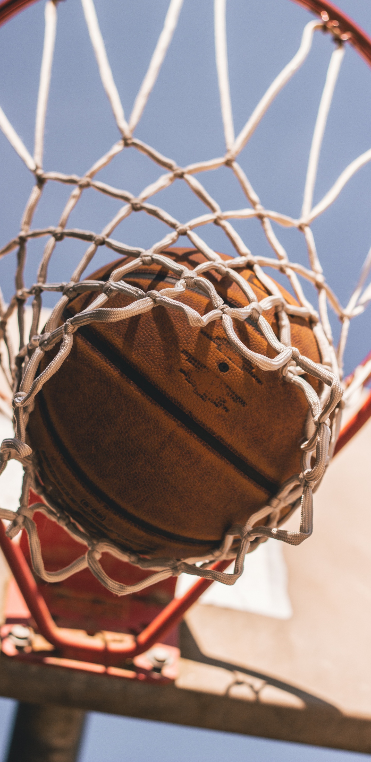 Brown Basketball on Basketball Hoop. Wallpaper in 1440x2960 Resolution