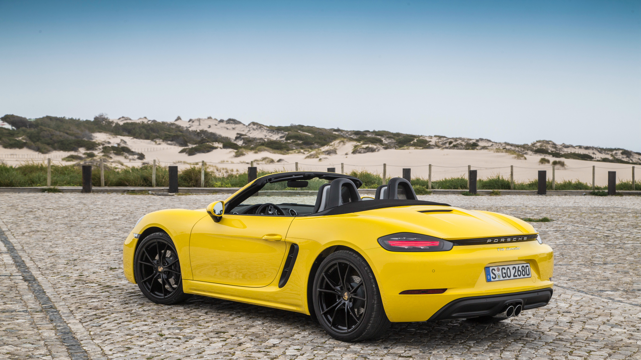 Yellow Porsche 911 on Gray Sand During Daytime. Wallpaper in 2560x1440 Resolution