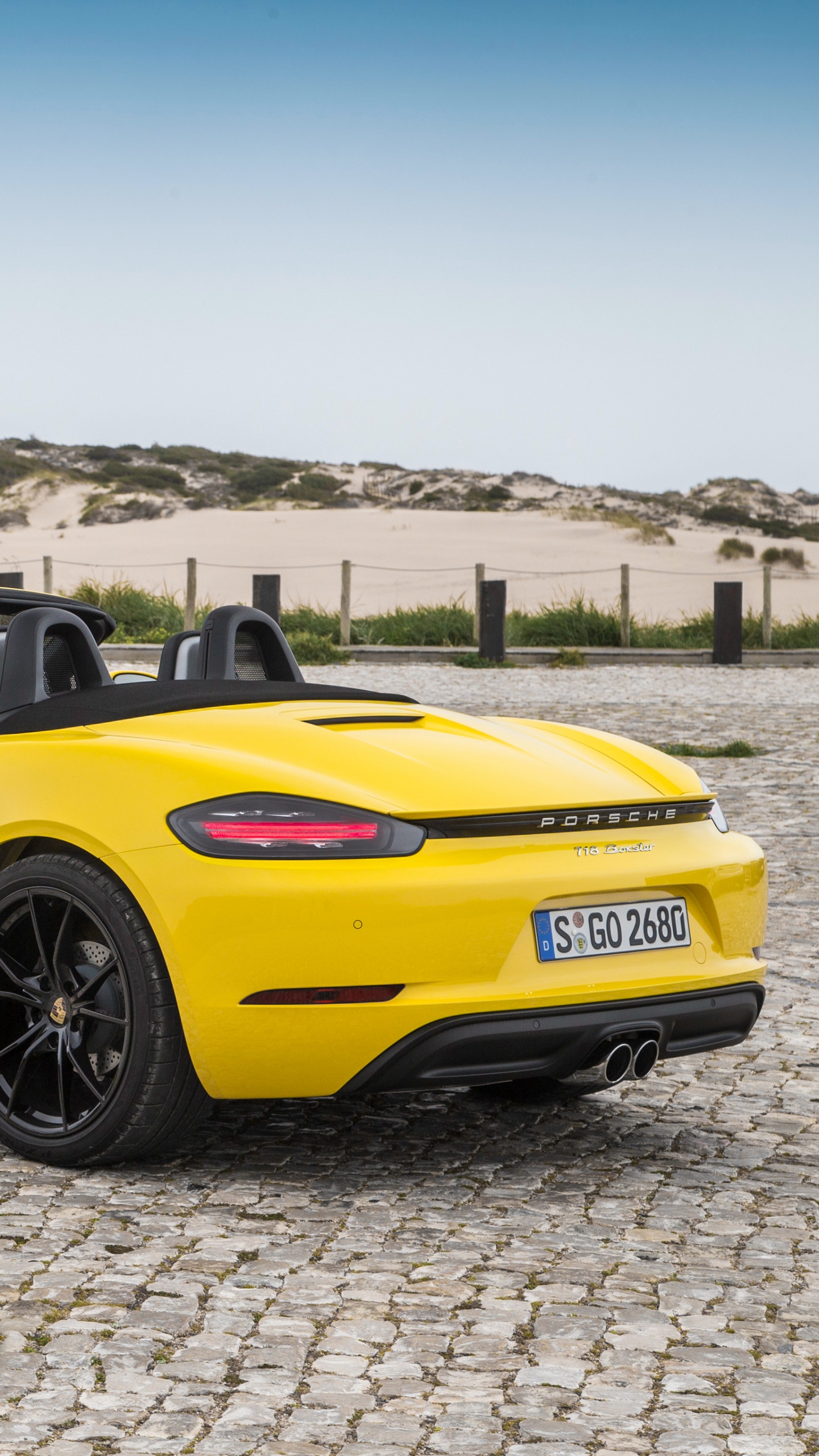 Gelber Porsche 911 Auf Grauem Sand Tagsüber. Wallpaper in 1440x2560 Resolution