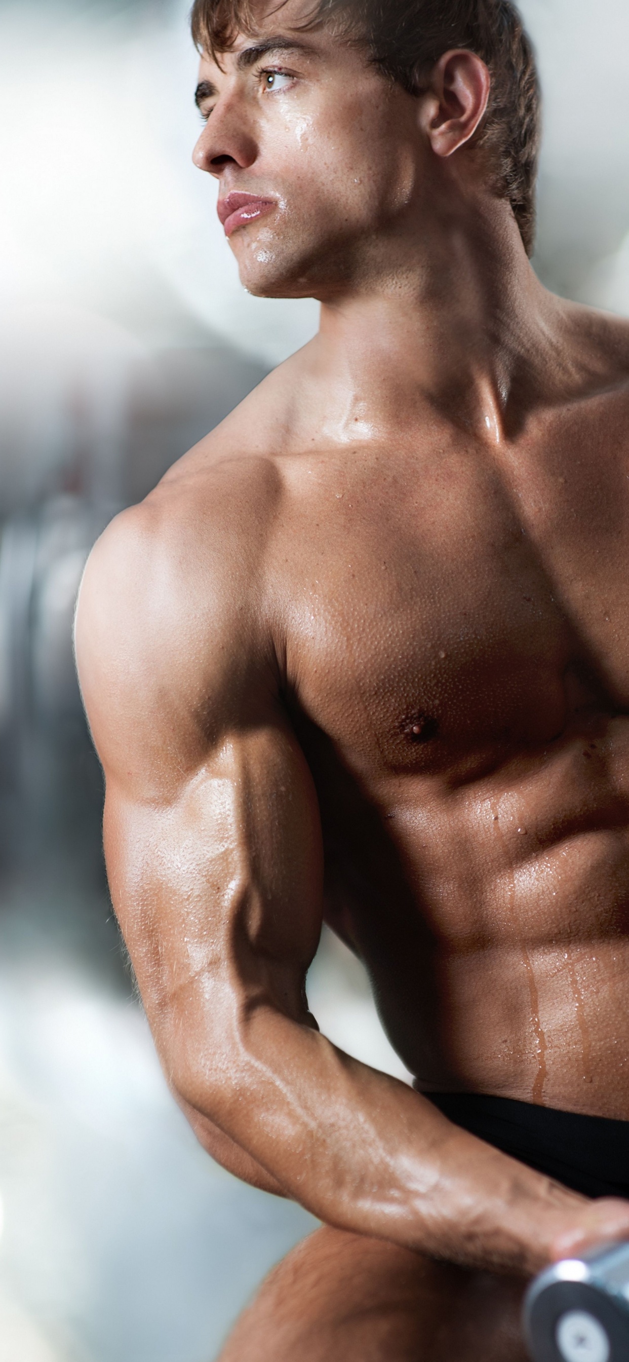 Topless Man in Black Shorts Holding Black Dumbbell. Wallpaper in 1242x2688 Resolution
