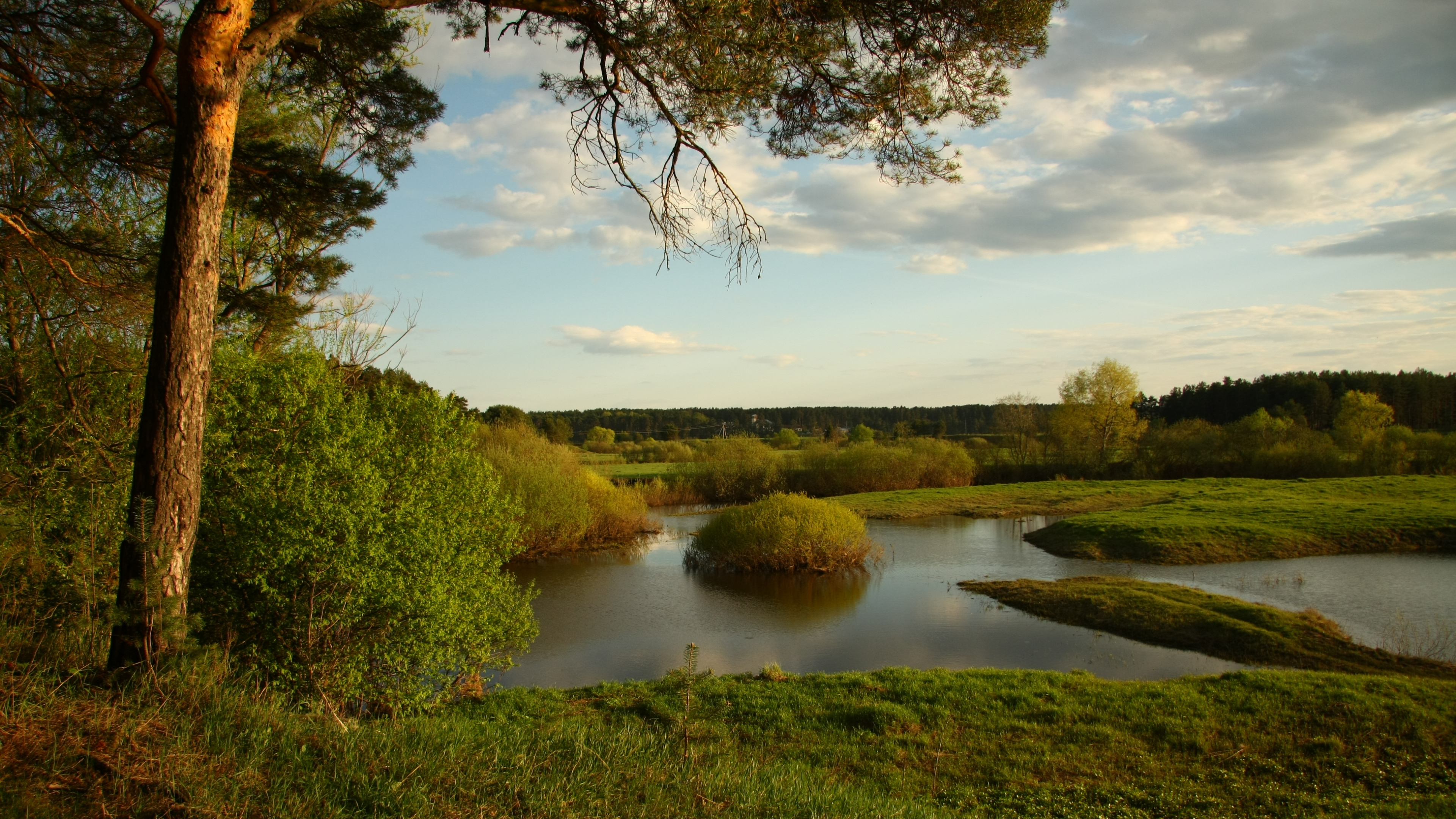 Grüne Wiese in Der Nähe Des Sees Unter Blauem Himmel Tagsüber. Wallpaper in 3840x2160 Resolution