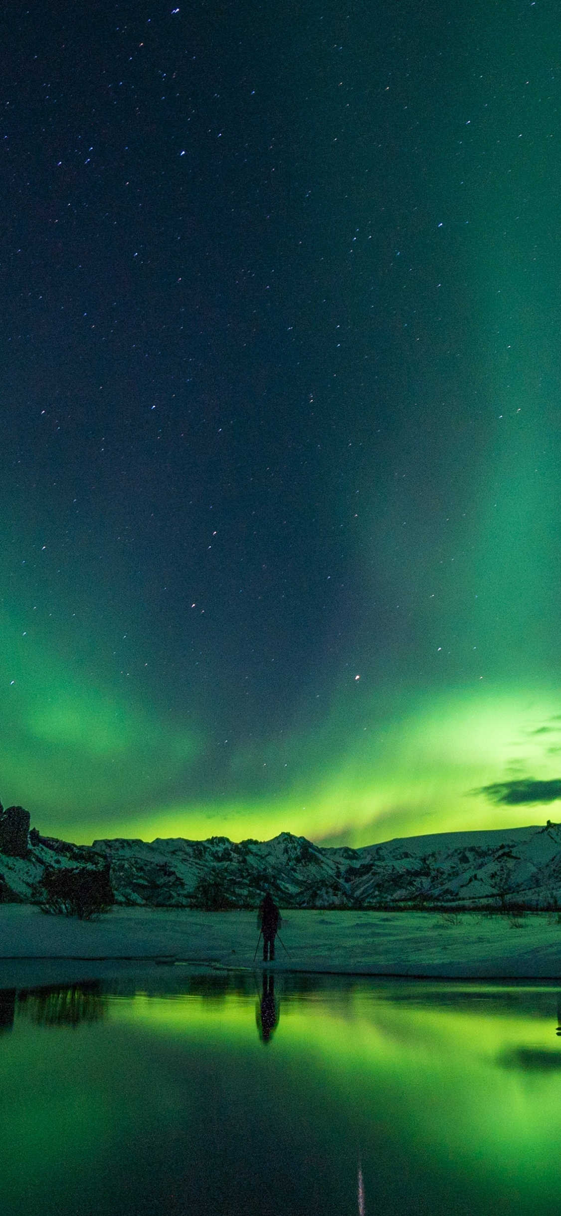 Gewässer in Der Nähe Des Berges Während Der Nachtzeit. Wallpaper in 1125x2436 Resolution