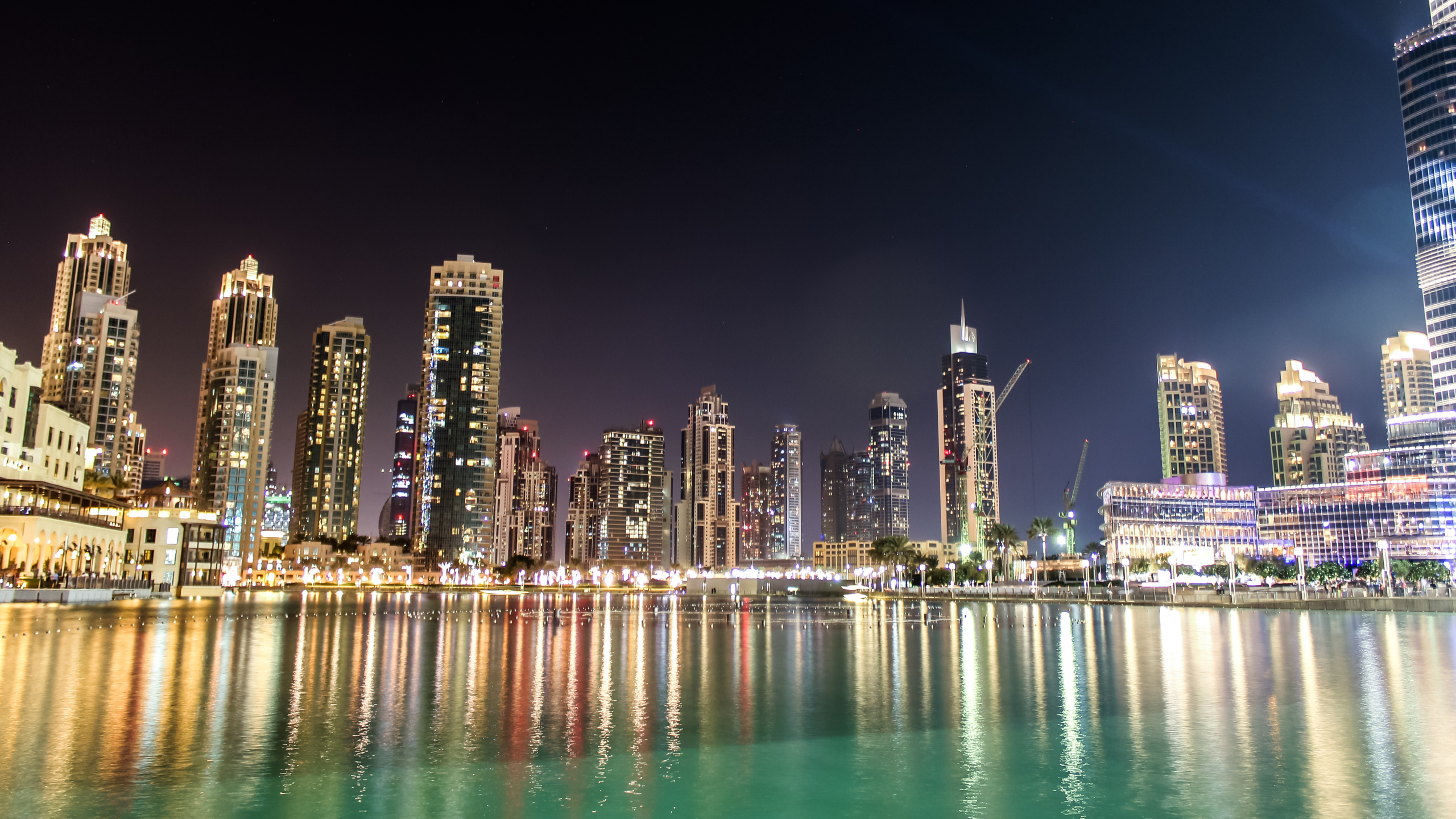 City Skyline Across Body of Water During Night Time. Wallpaper in 2560x1440 Resolution