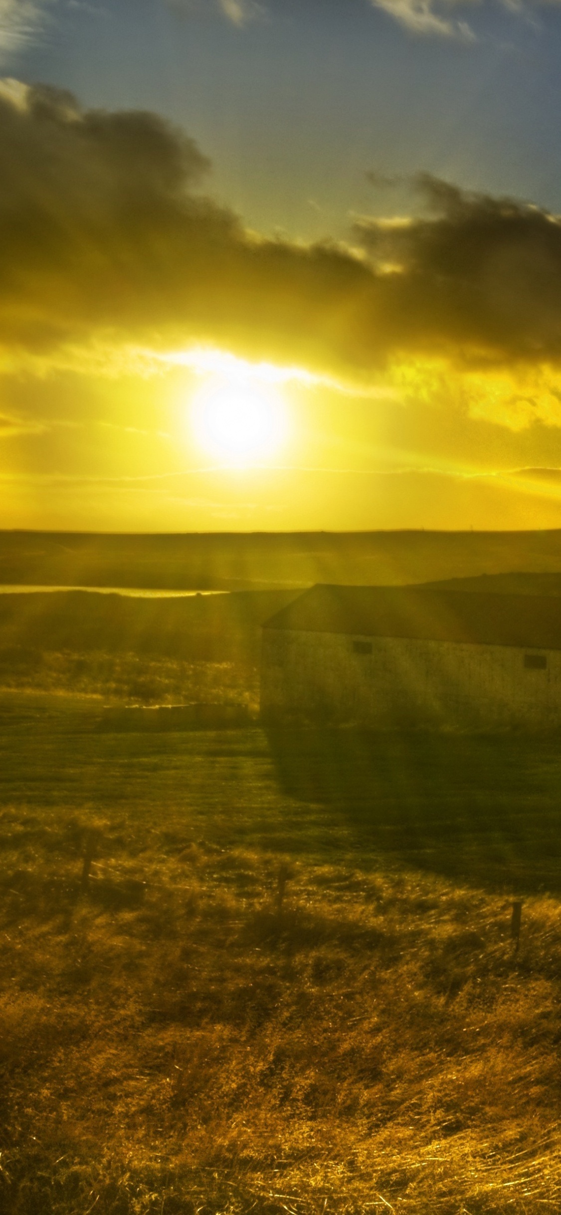 Green Grass Field Under Cloudy Sky During Daytime. Wallpaper in 1125x2436 Resolution