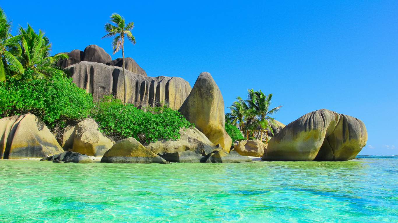 Brown Rock Formation Beside Body of Water During Daytime. Wallpaper in 1366x768 Resolution