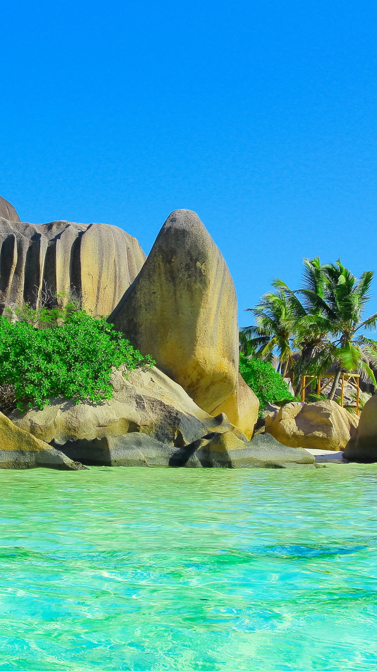 Brown Rock Formation Beside Body of Water During Daytime. Wallpaper in 750x1334 Resolution