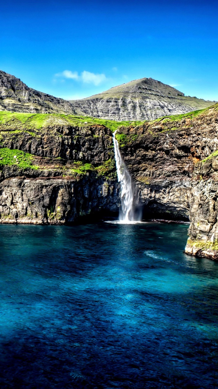 Green and Brown Mountain Beside Blue Sea Under Blue Sky During Daytime. Wallpaper in 720x1280 Resolution