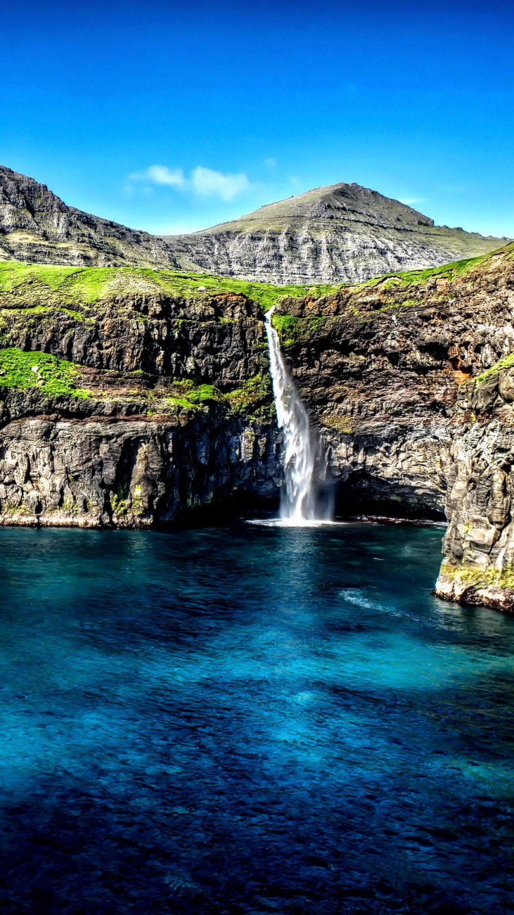 Green and Brown Mountain Beside Blue Sea Under Blue Sky During Daytime. Wallpaper in 750x1334 Resolution