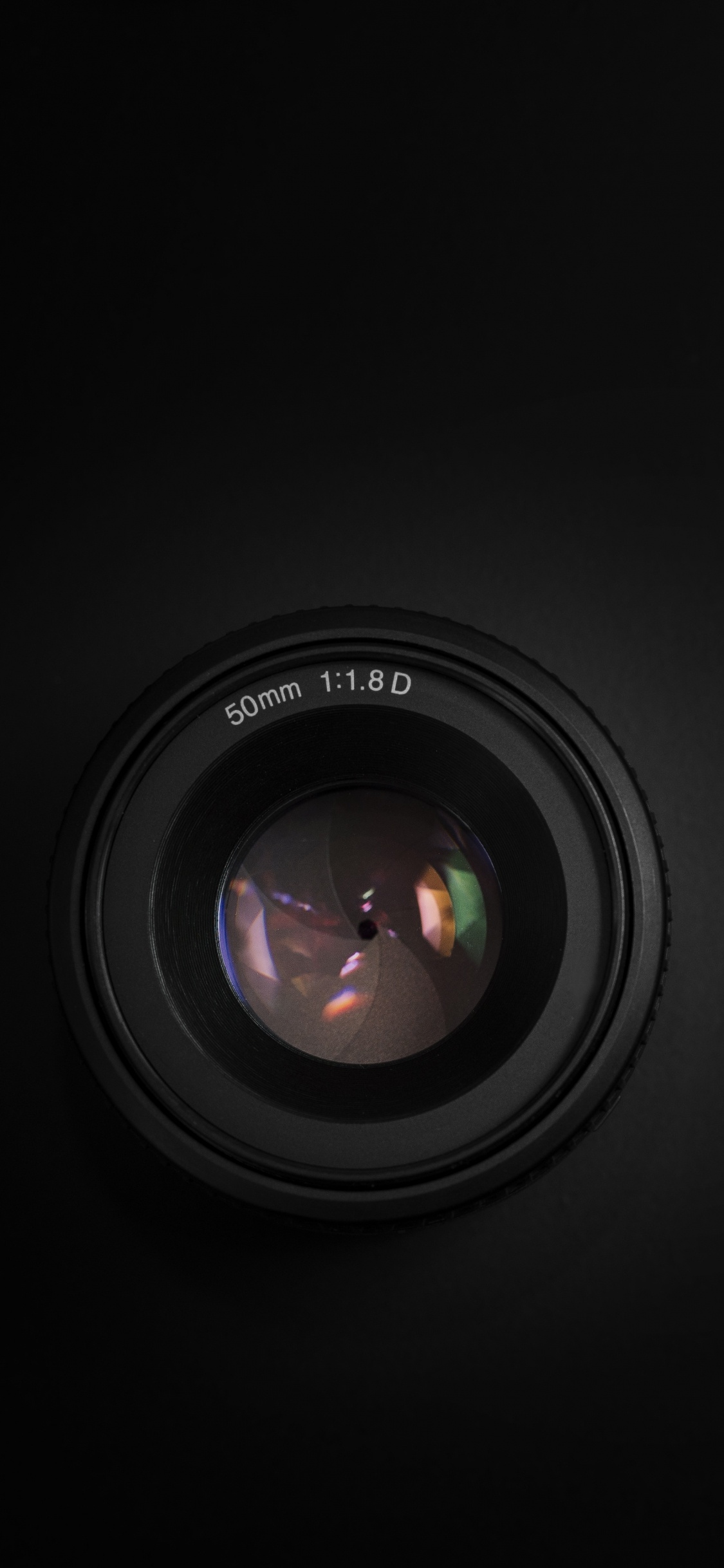 Black Camera Lens on Black Surface. Wallpaper in 1125x2436 Resolution