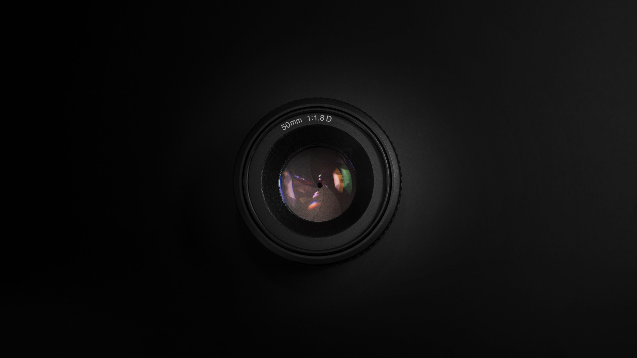 Black Camera Lens on Black Surface. Wallpaper in 2560x1440 Resolution