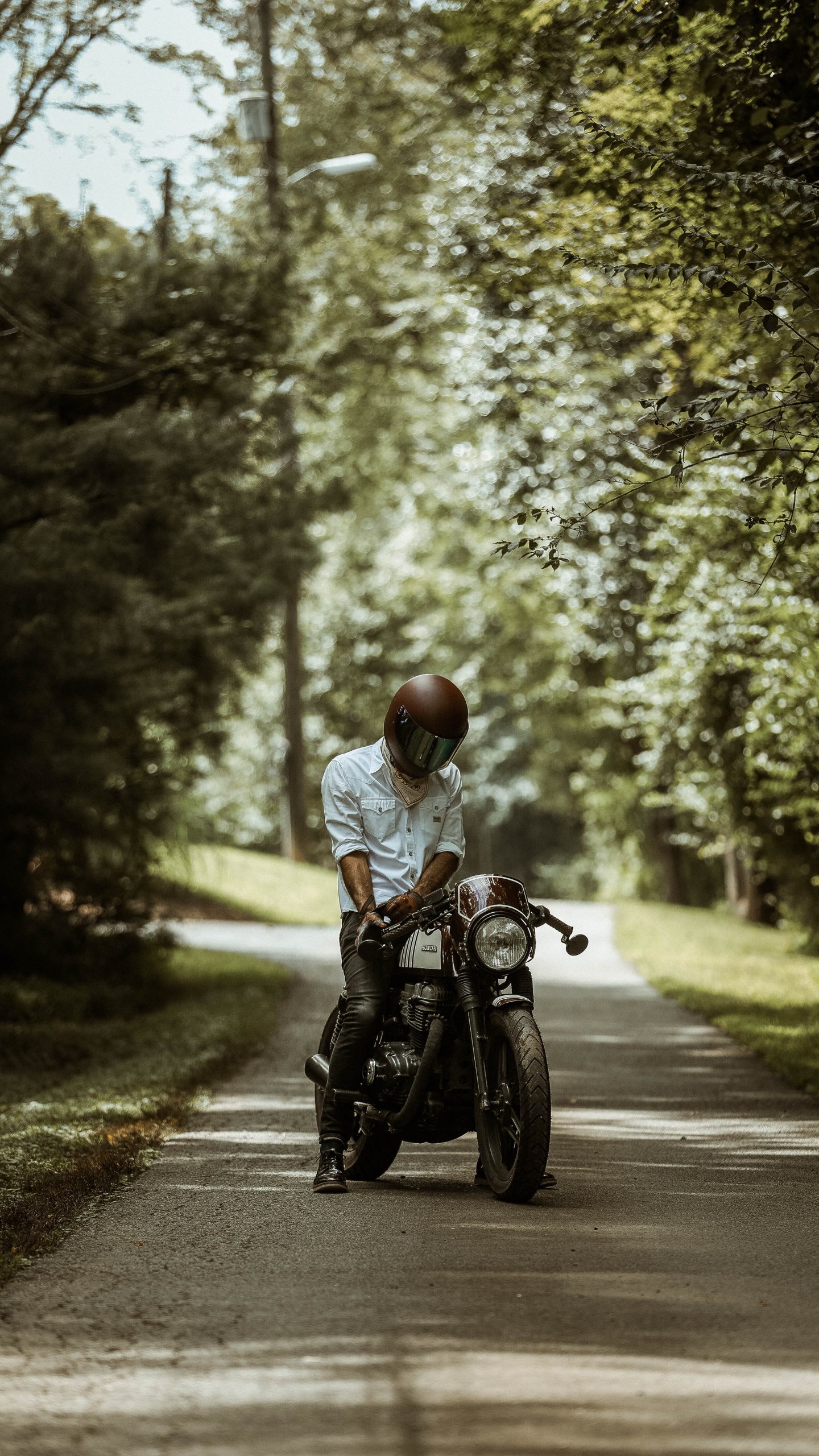 L'homme en Chemise Blanche Équitation Moto Sur Route Pendant la Journée. Wallpaper in 1440x2560 Resolution