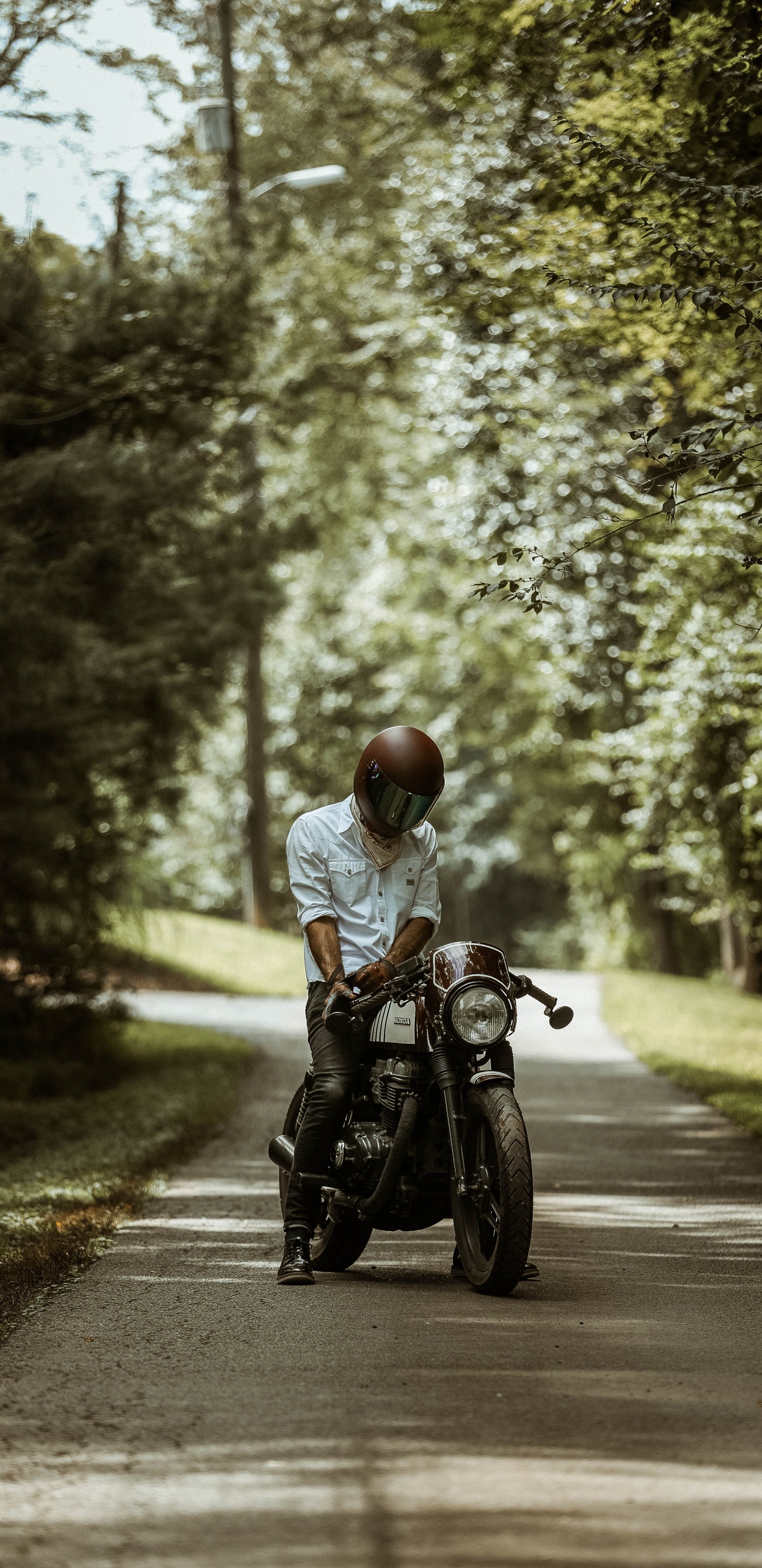 L'homme en Chemise Blanche Équitation Moto Sur Route Pendant la Journée. Wallpaper in 1440x2960 Resolution