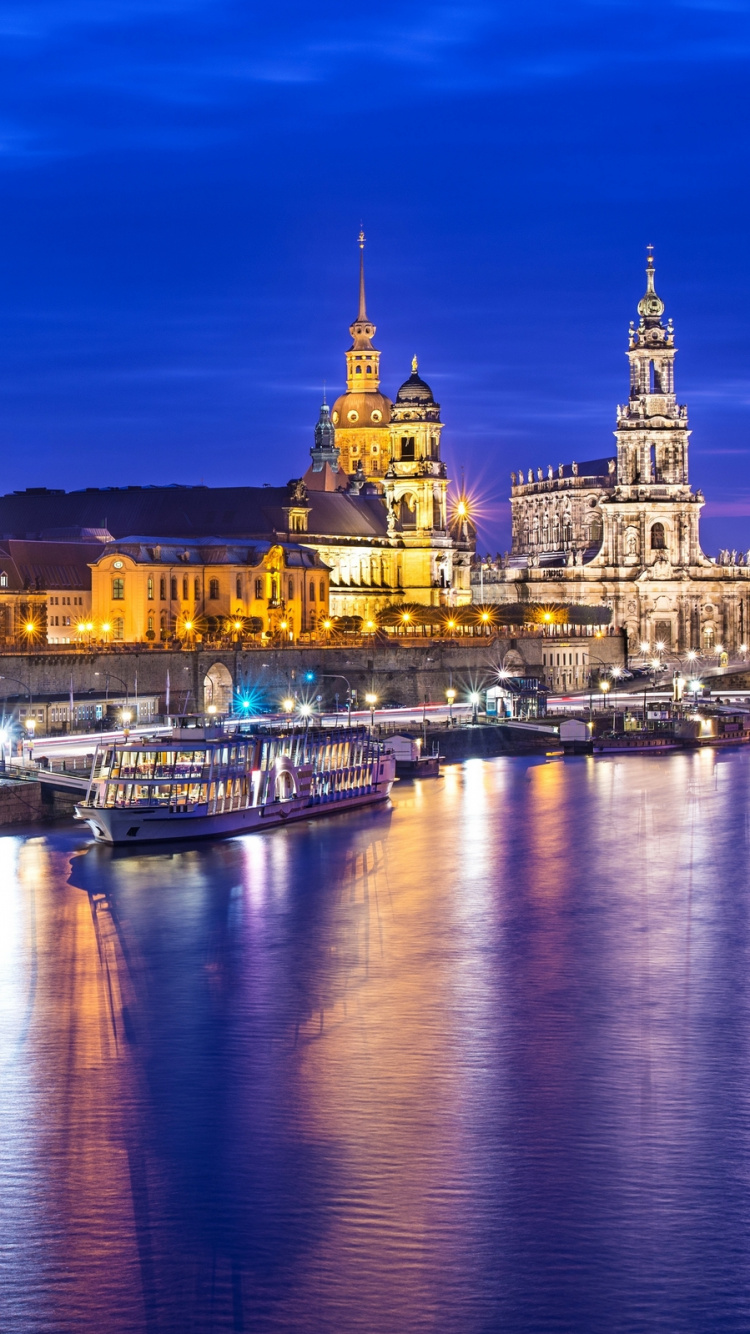 Weißes Und Braunes Betongebäude in Der Nähe Eines Gewässers Während Der Nacht. Wallpaper in 750x1334 Resolution