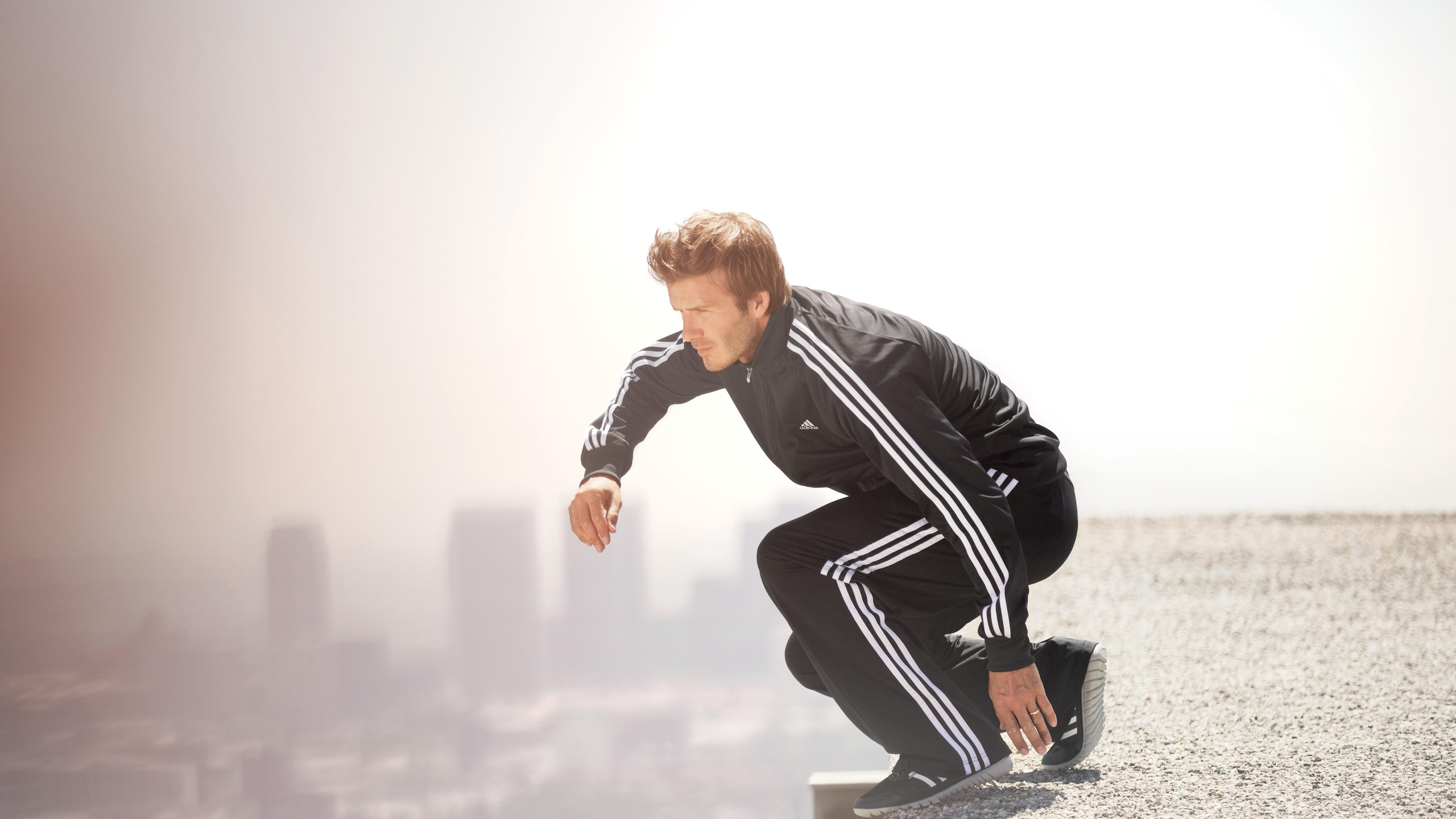 Mann in Schwarzer Lederjacke Und Schwarzer Hose, Der Tagsüber Auf Einer Weißen Betonbank Sitzt. Wallpaper in 2560x1440 Resolution