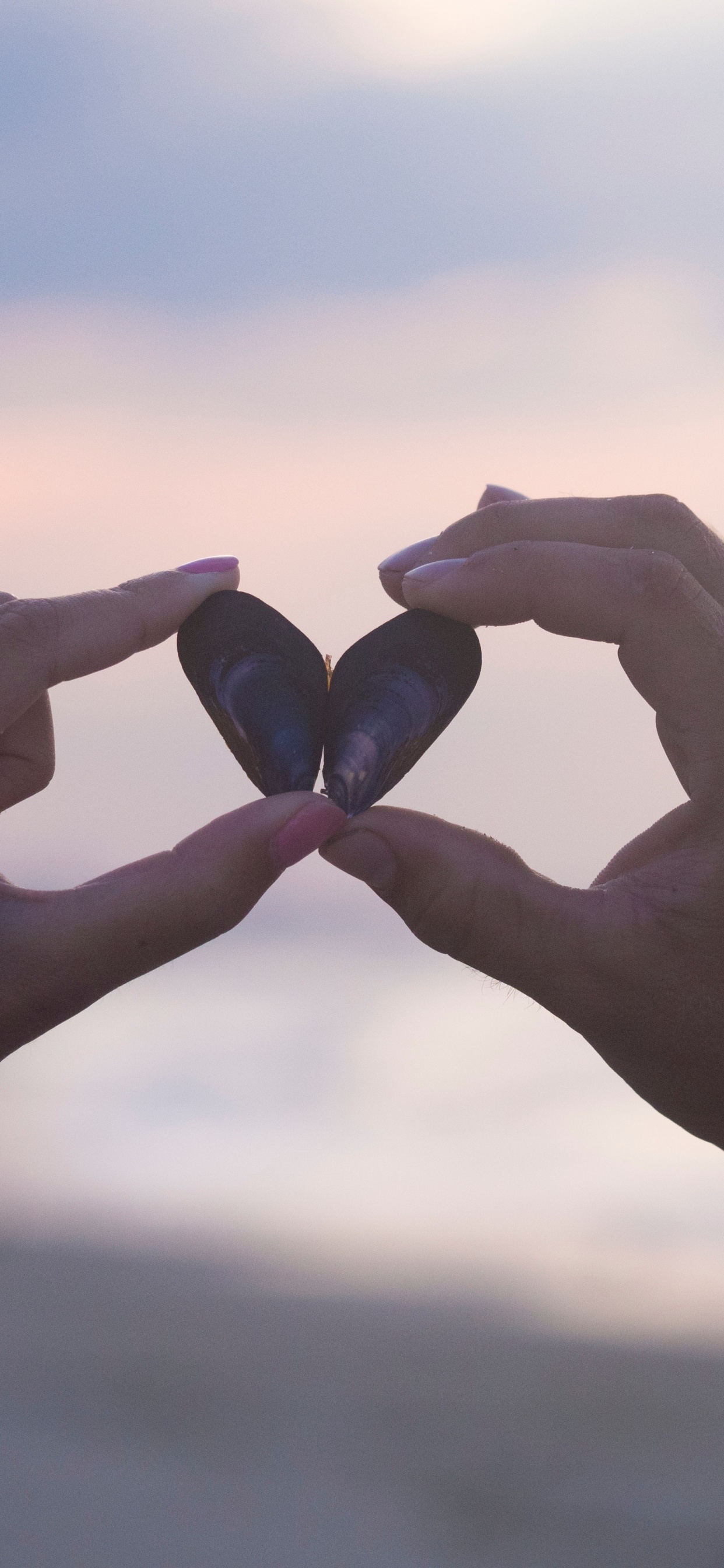 Persona Sosteniendo Piedra Negra Durante el Día. Wallpaper in 1242x2688 Resolution