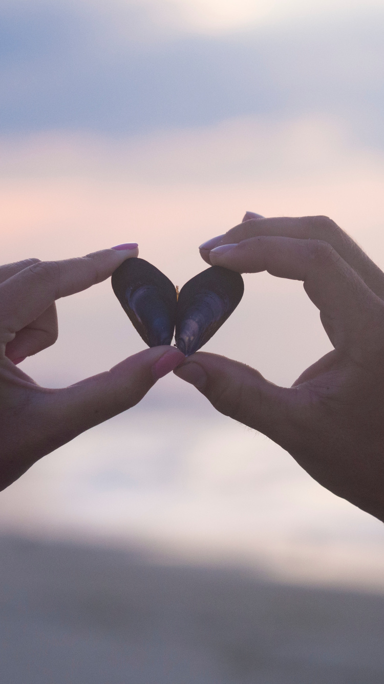 Person Holding Black Stone During Daytime. Wallpaper in 750x1334 Resolution