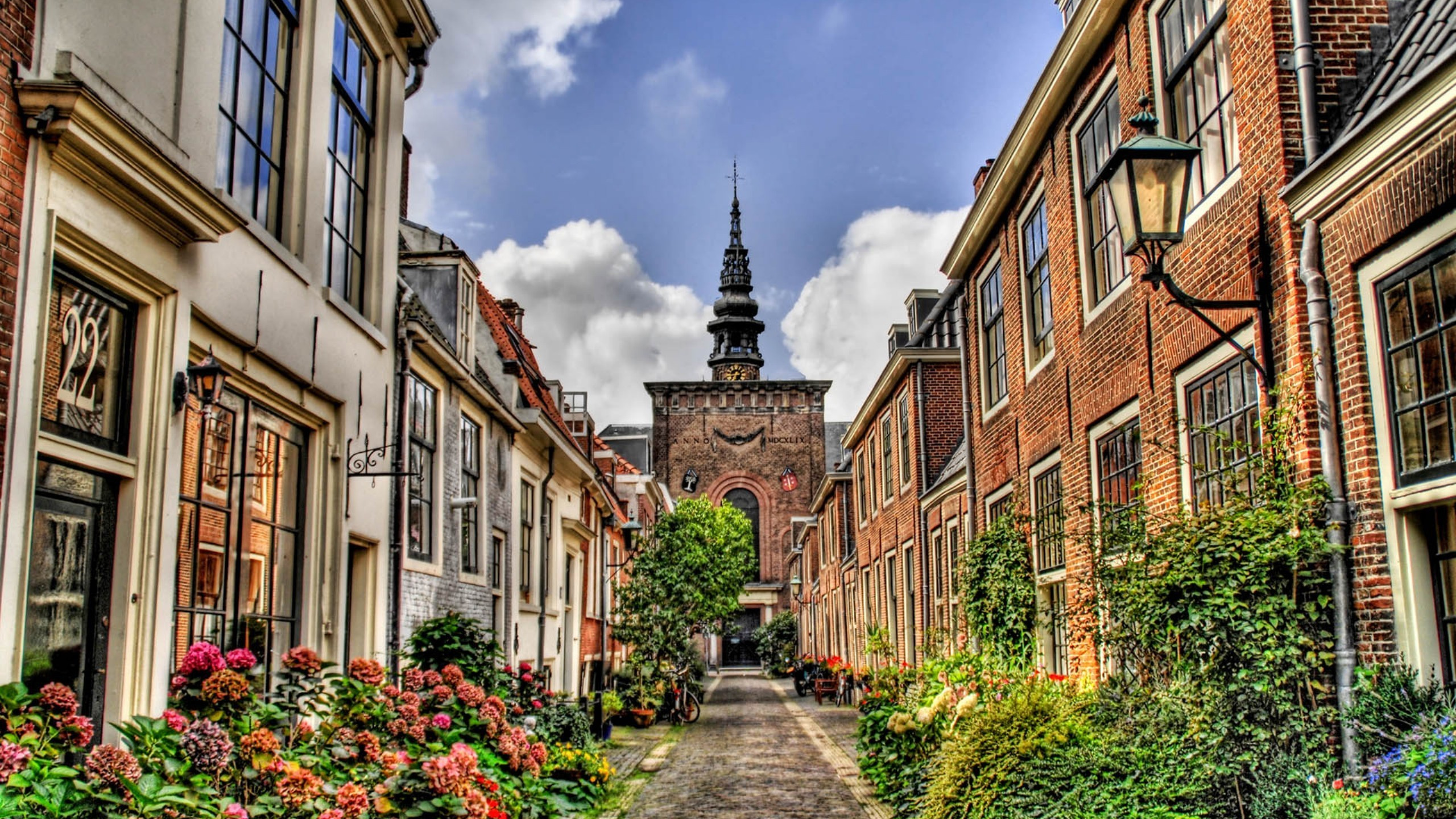 Bâtiment en Béton Brun Sous Ciel Nuageux Pendant la Journée. Wallpaper in 2560x1440 Resolution